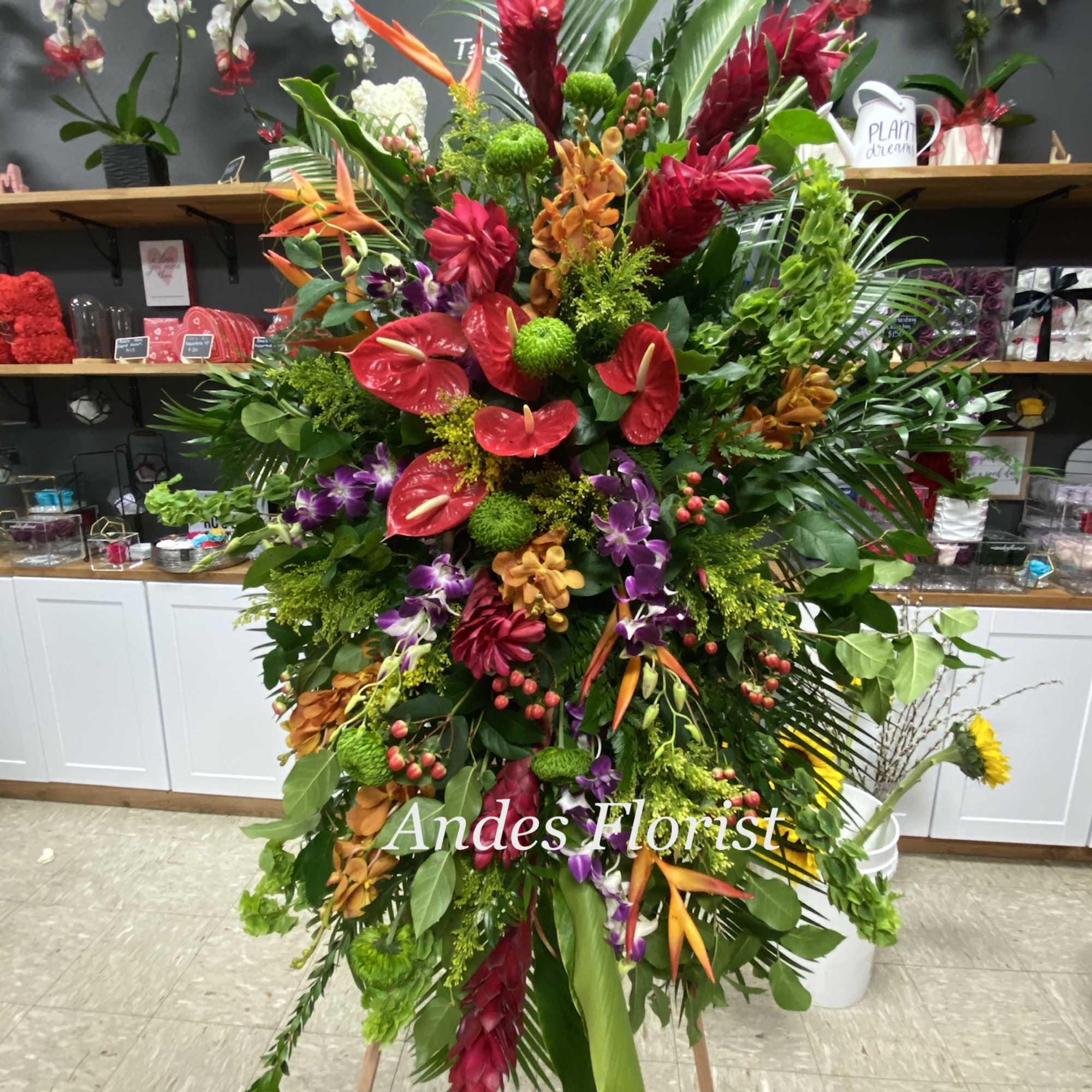 Large tropical floral standing spray with red, orange, purple, and green blooms
