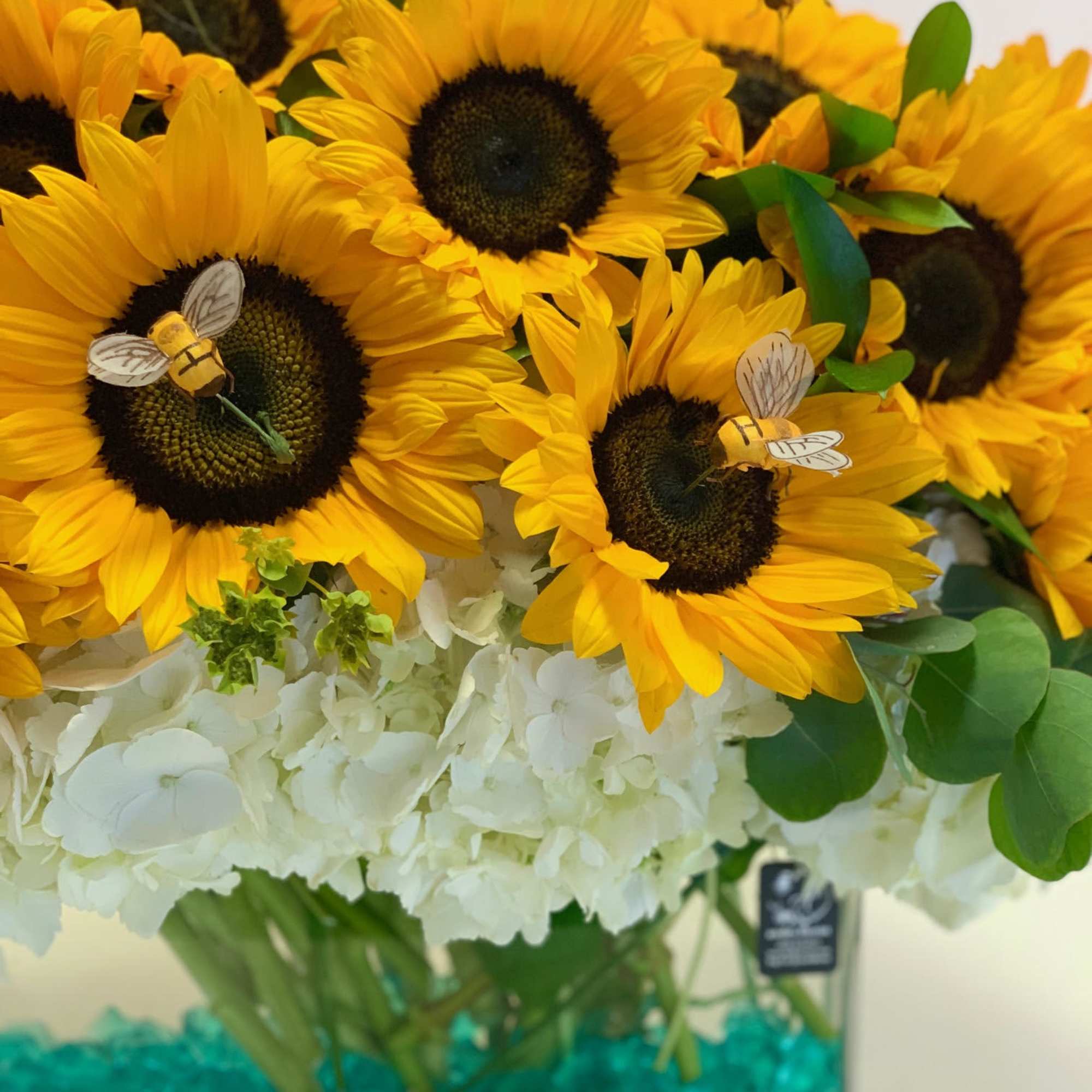 Sunflower bouquet with white hydrangeas in a glass vase