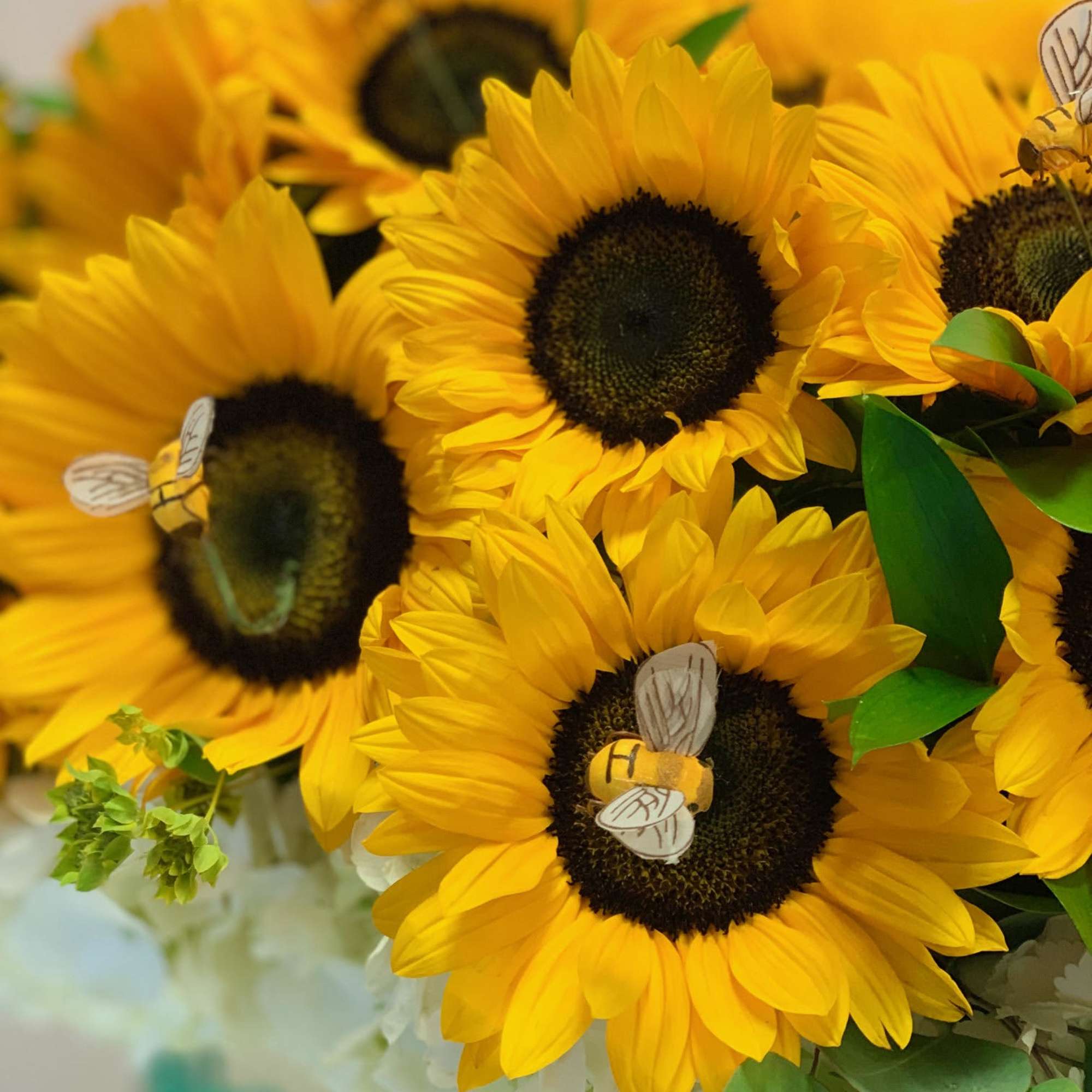 Bouquet of yellow sunflowers with small bee decorations