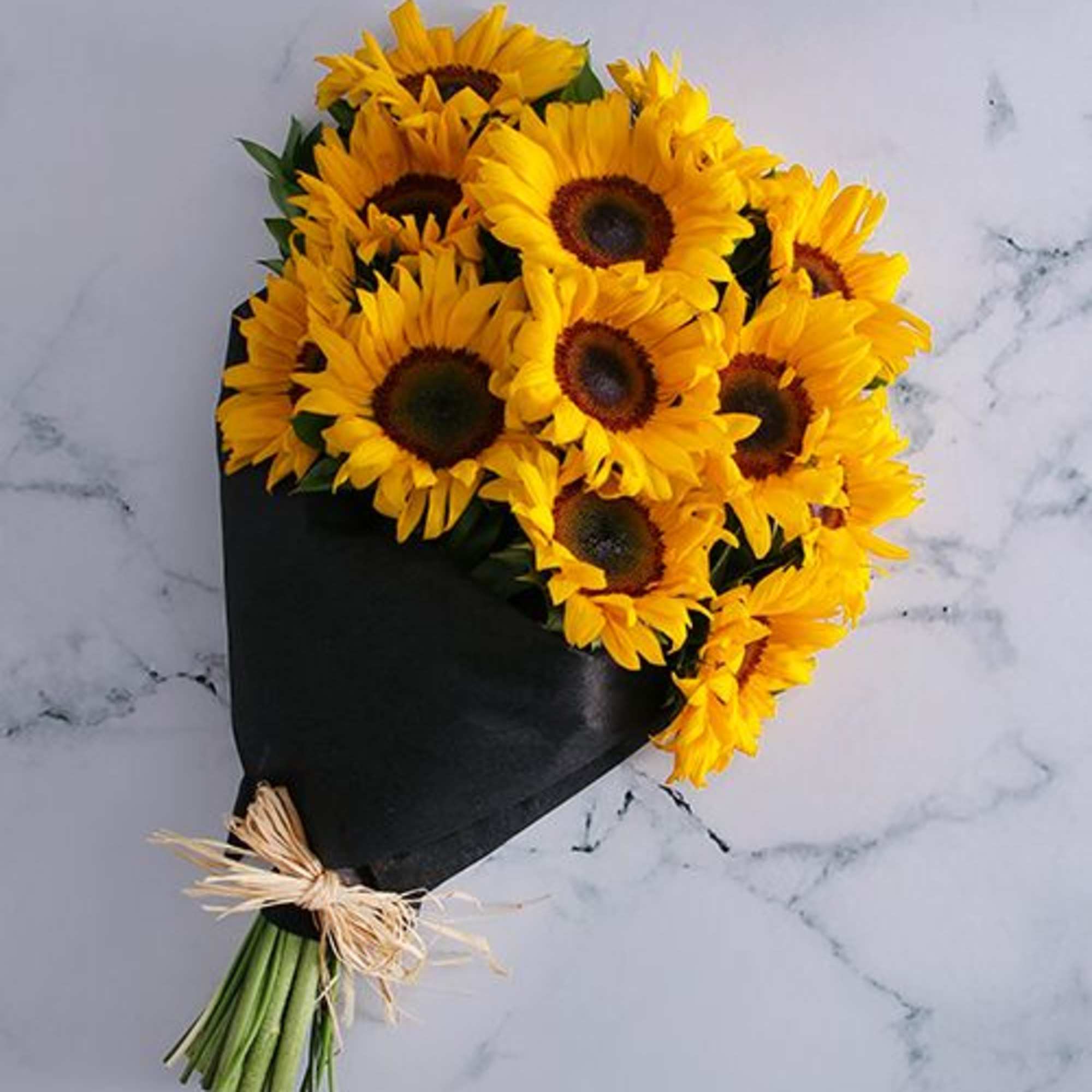 Bouquet of yellow sunflowers wrapped in black paper