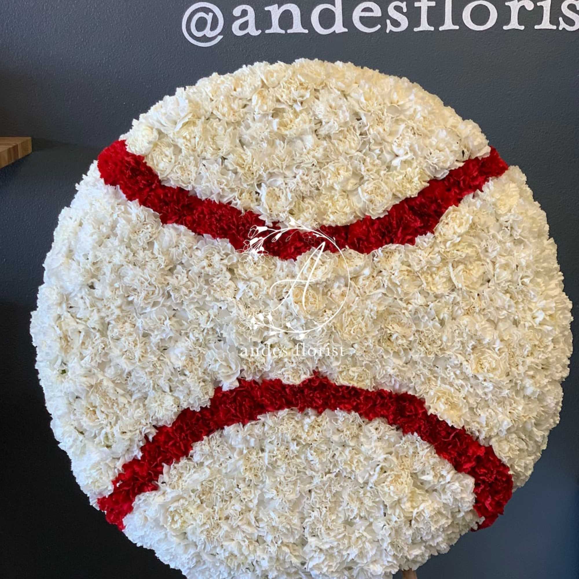 Large round floral tribute shaped like a baseball
