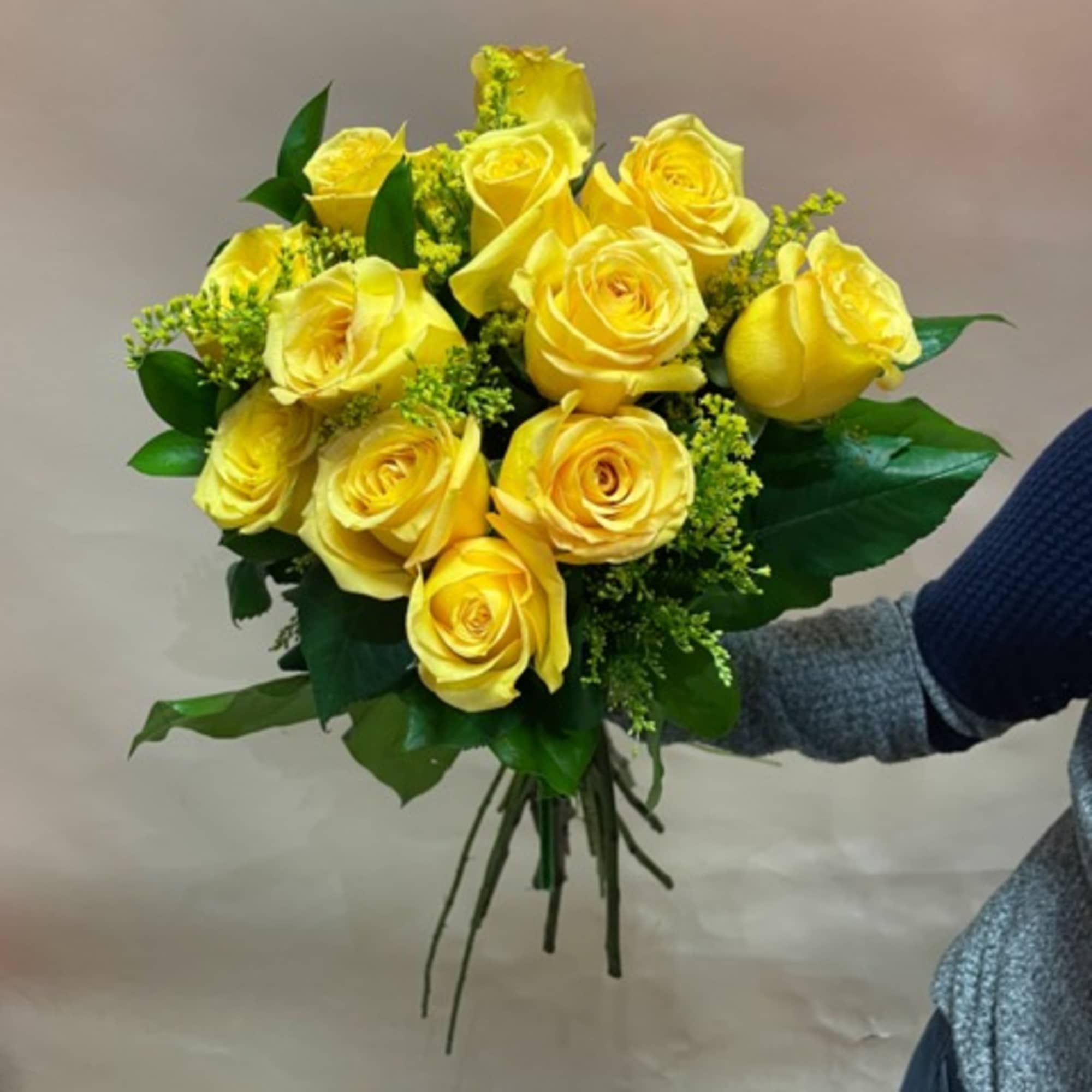 Bouquet of yellow roses with green filler and leaves