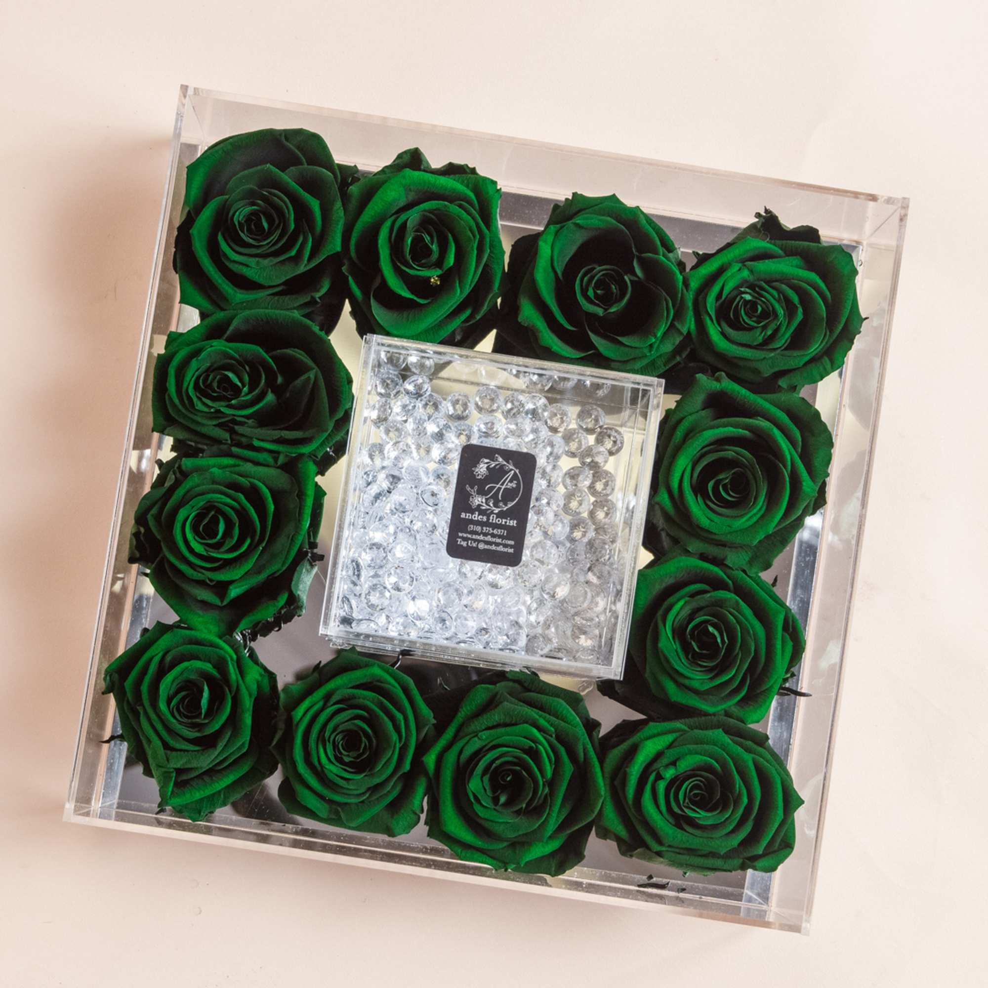 Green roses arranged in a clear square box with a crystal center