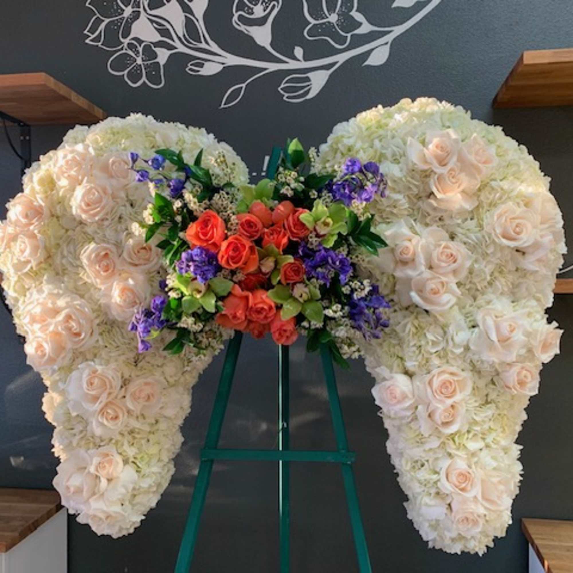 Large heart-shaped floral arrangement with cream and peach roses