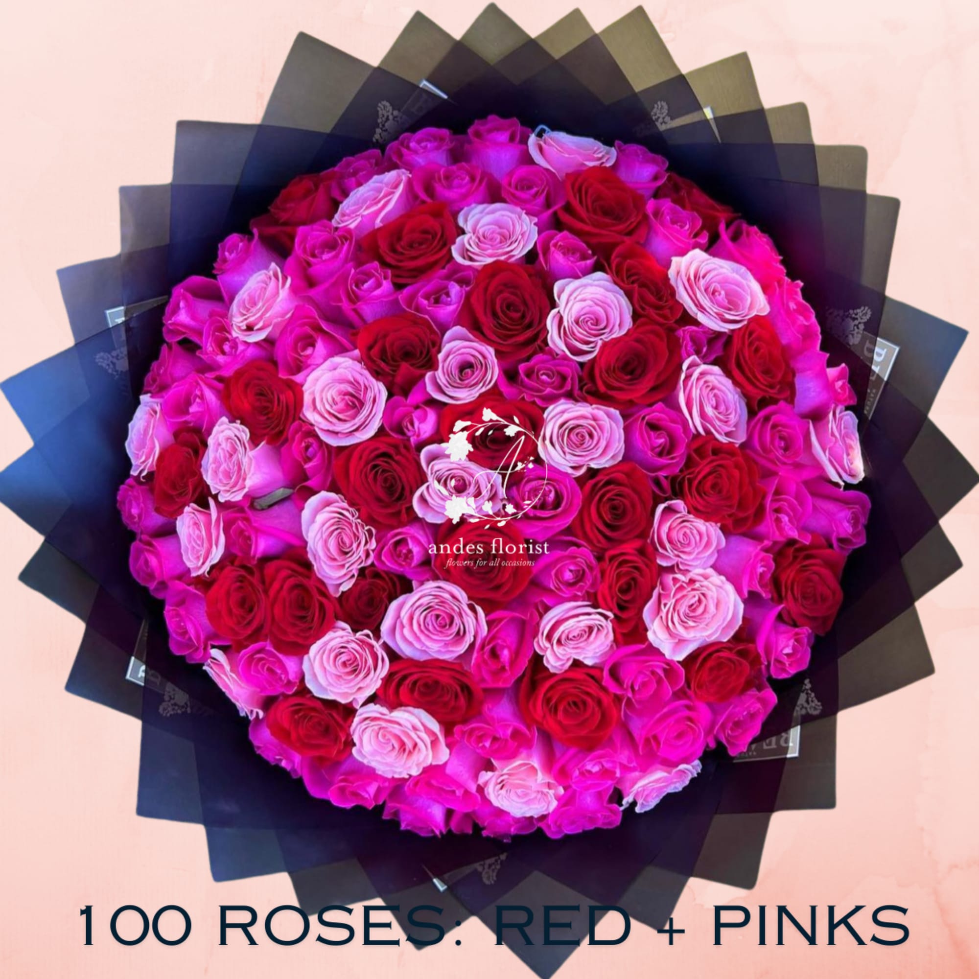 Round bouquet of red and pink roses wrapped in black paper