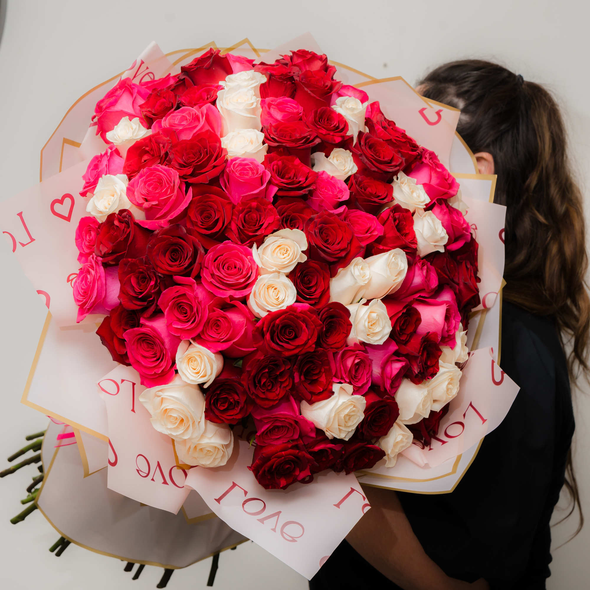 Large bouquet of red, pink, and white roses wrapped in pink paper, photo 6 of 10
