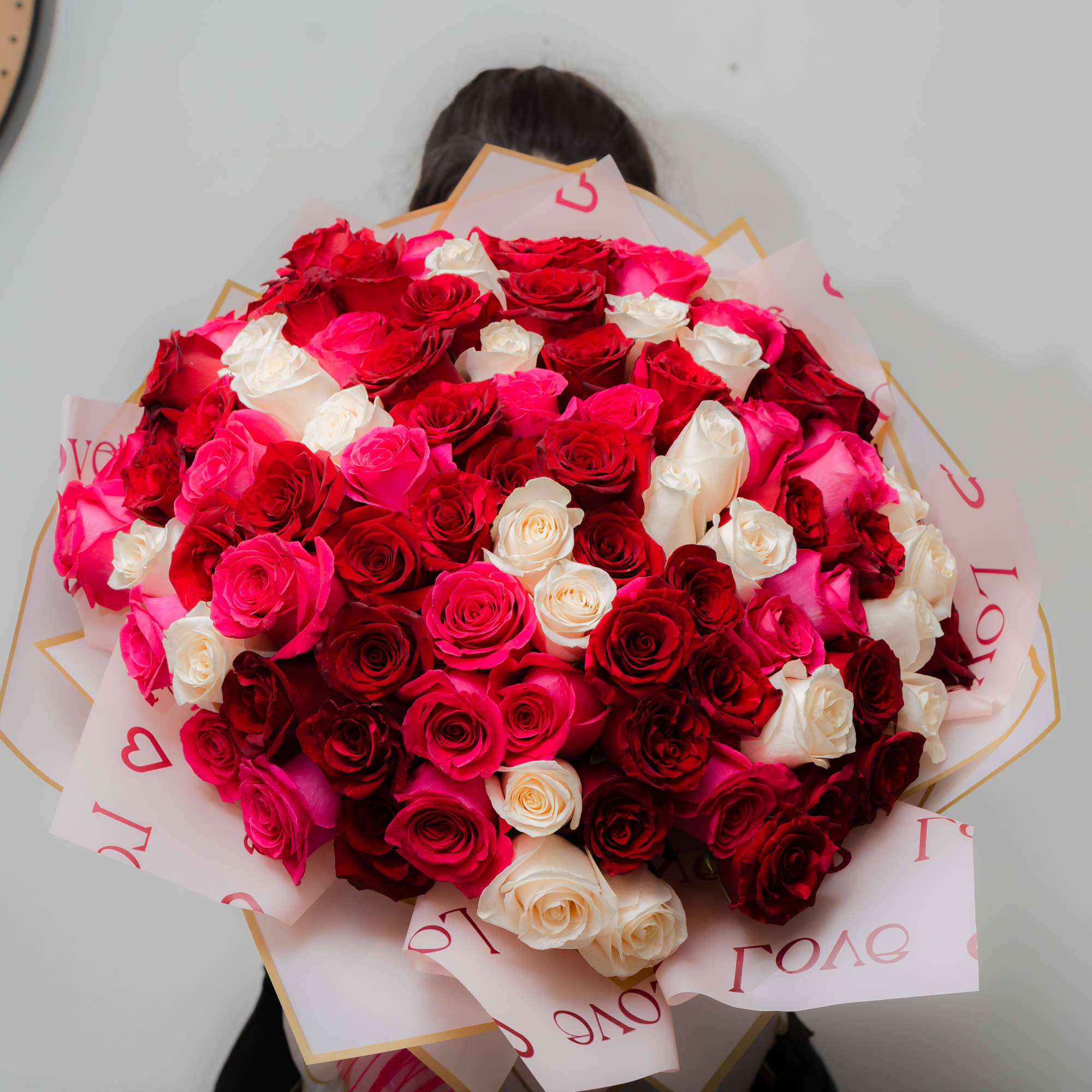 Large bouquet of red, pink, and white roses wrapped in pink paper, photo 7 of 10