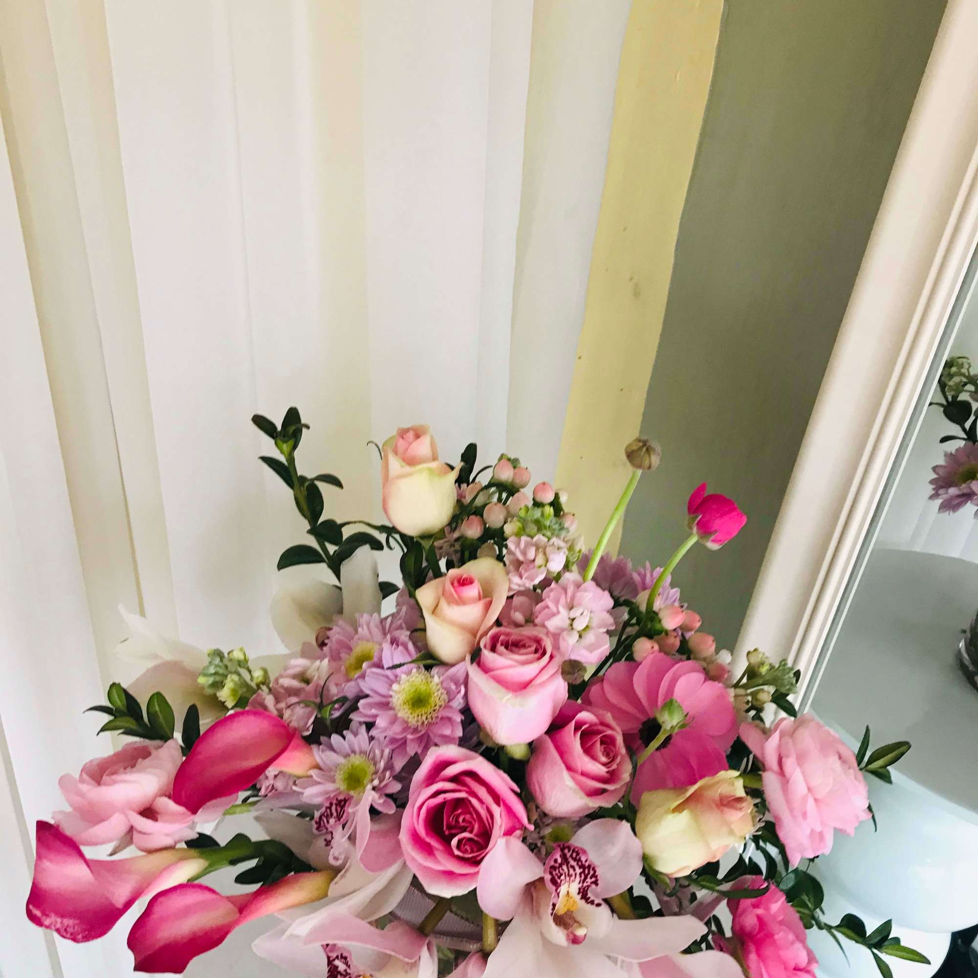Pink rose and orchid bouquet with calla lilies in a vase