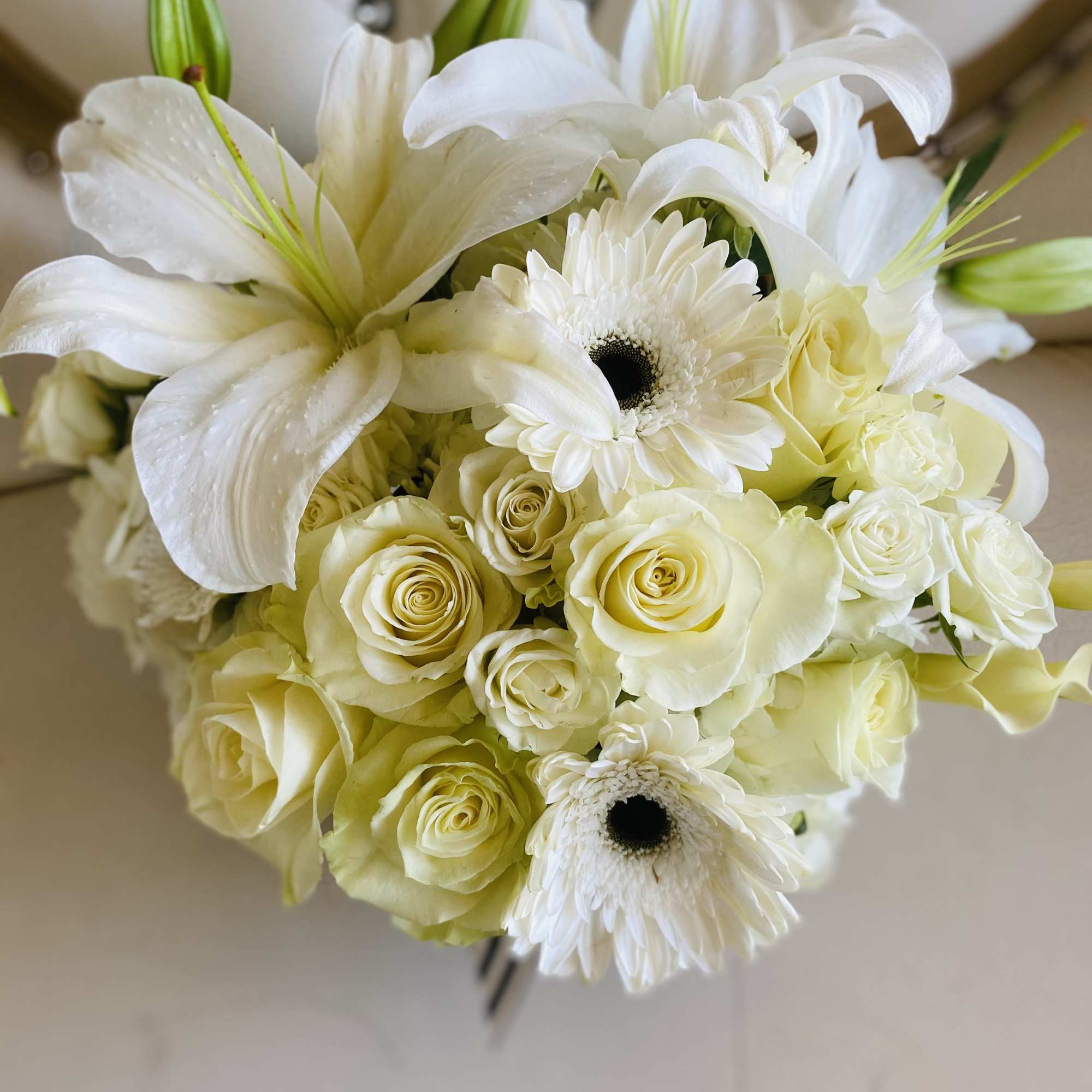 White lilies, roses, and gerbera daisies in a bouquet