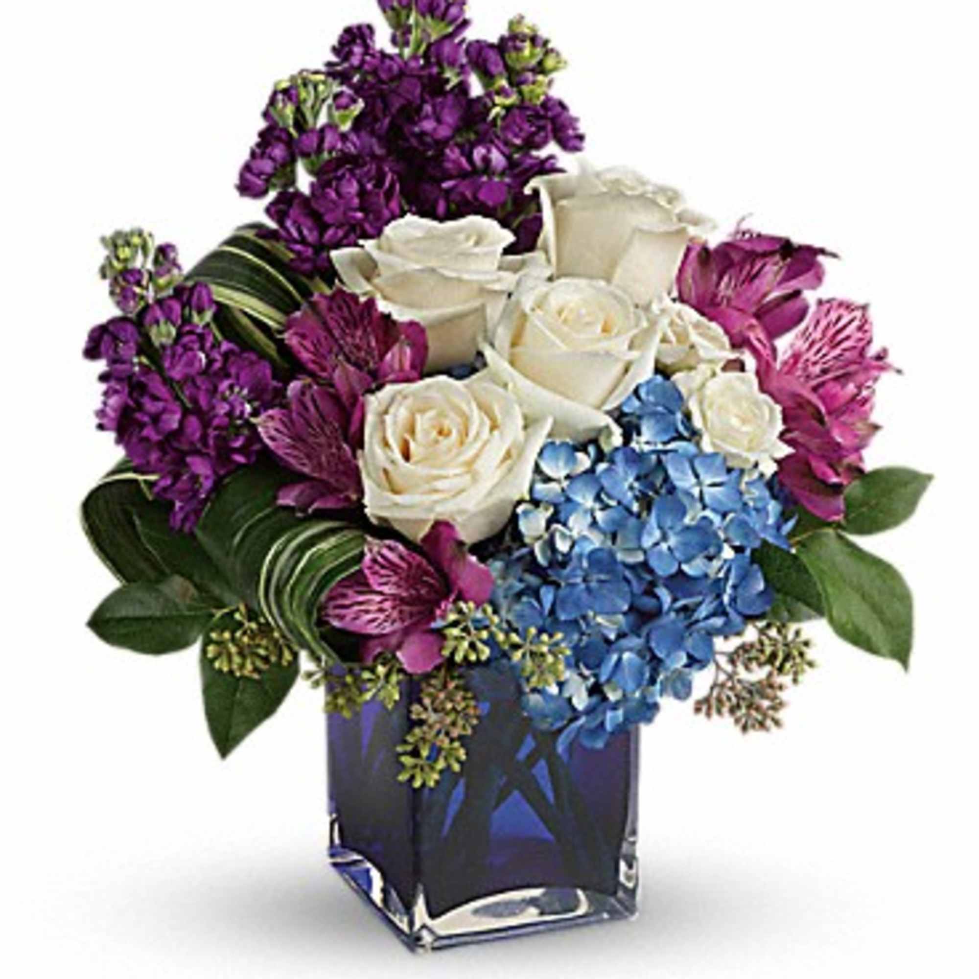 Purple and white floral arrangement in a square glass vase
