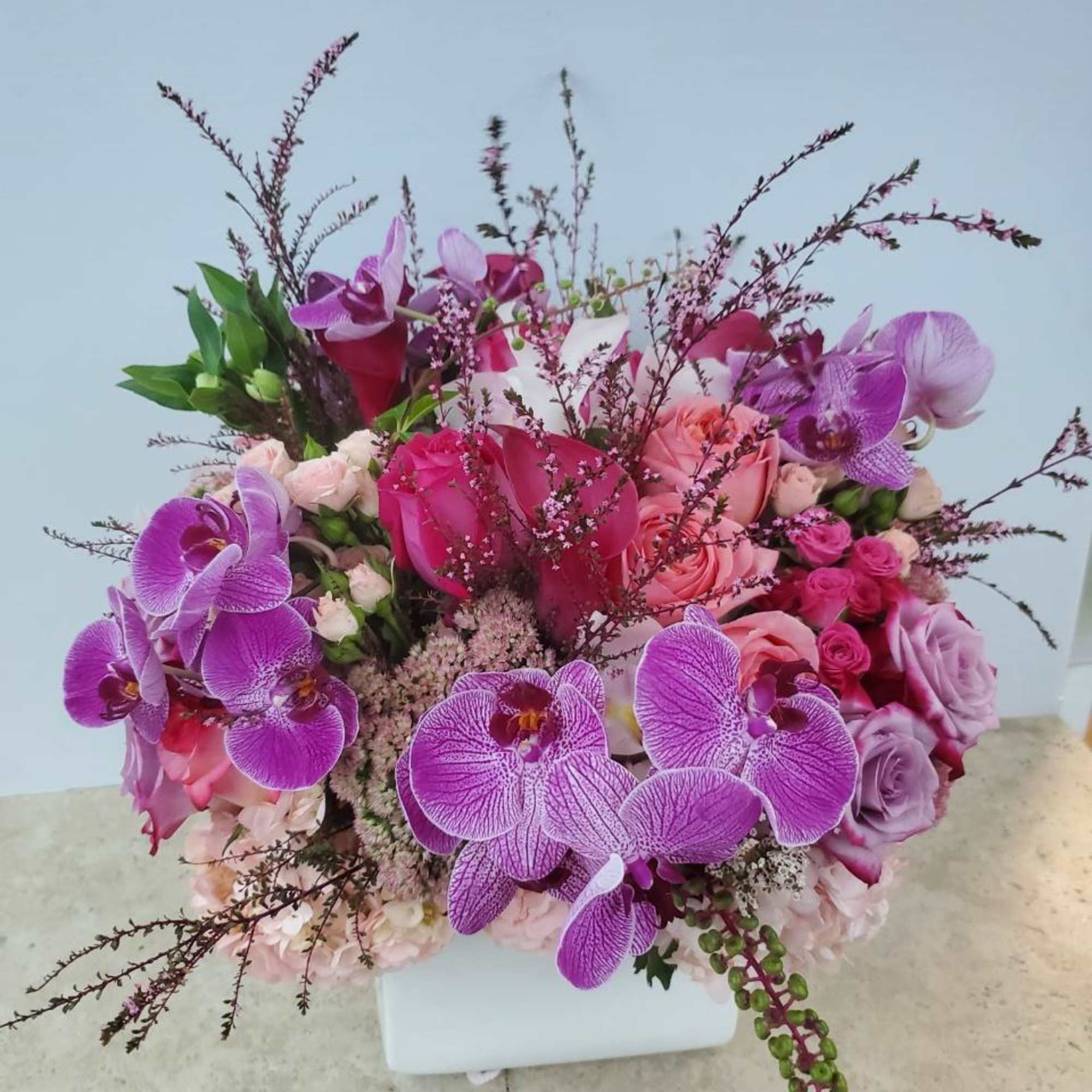 Pink and purple floral arrangement in a white vase