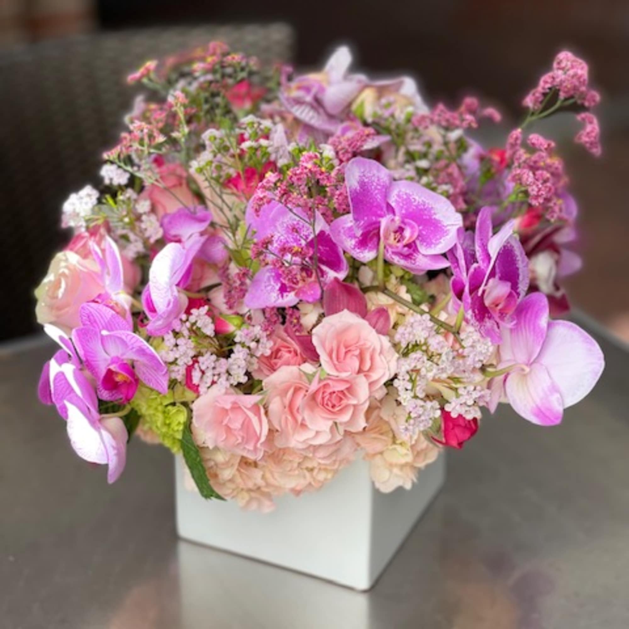 Pink and lavender floral arrangement in a white square vase, photo 8 of 14