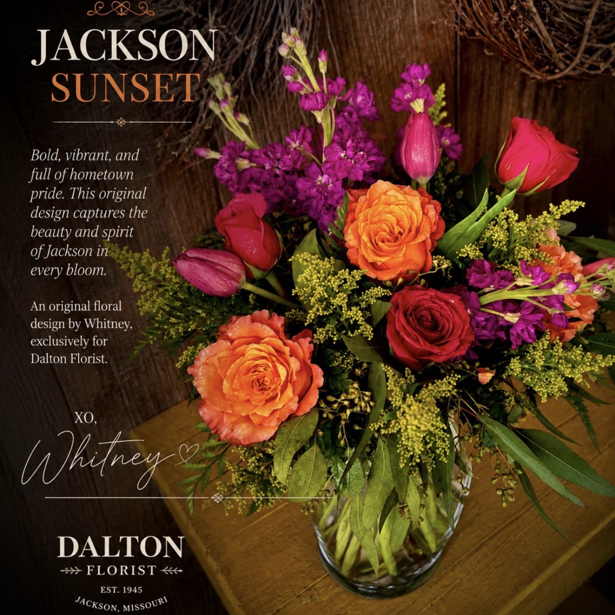Mixed bouquet of orange and red roses with purple blooms in a glass vase
