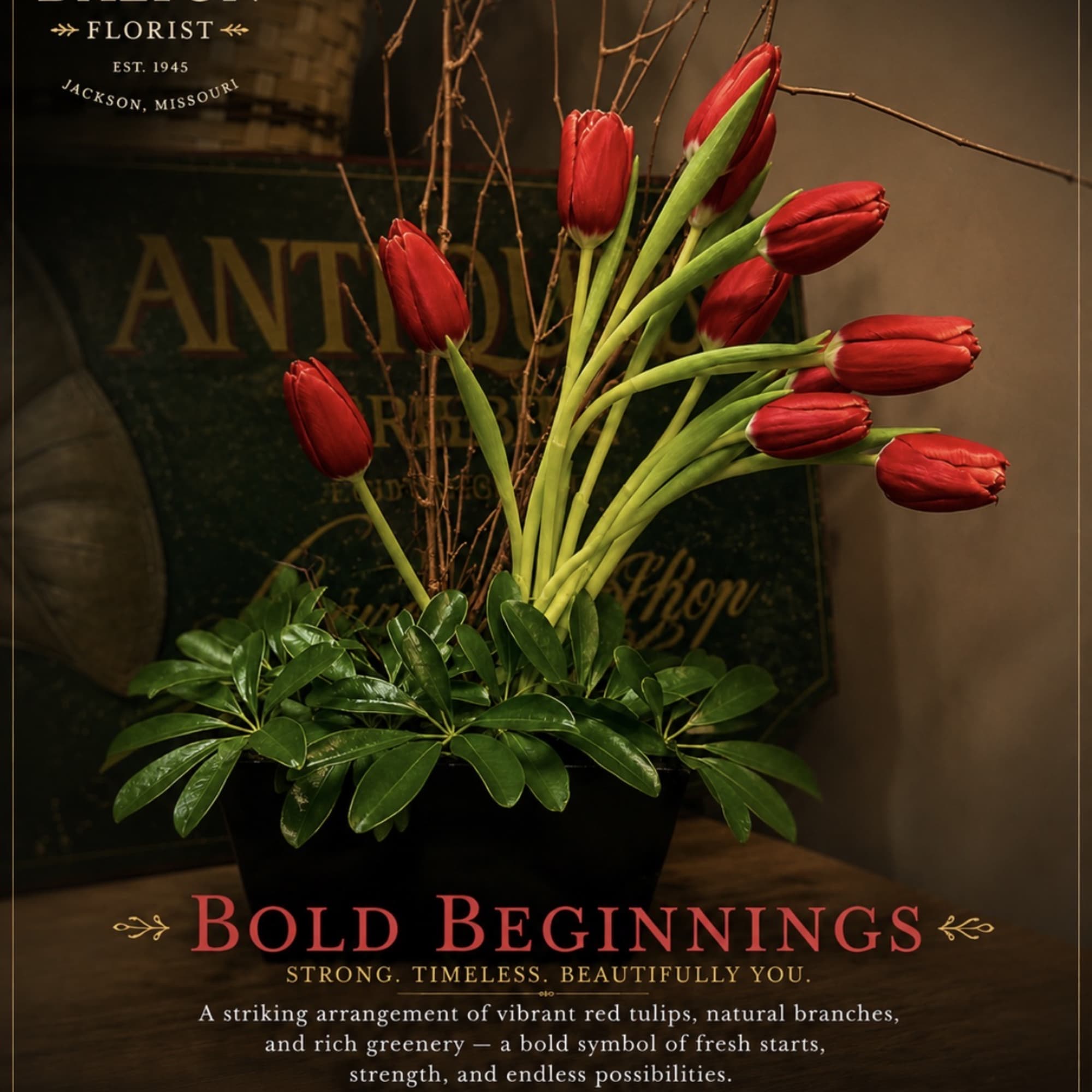 Arrangement of red tulips in a black container with glossy green foliage