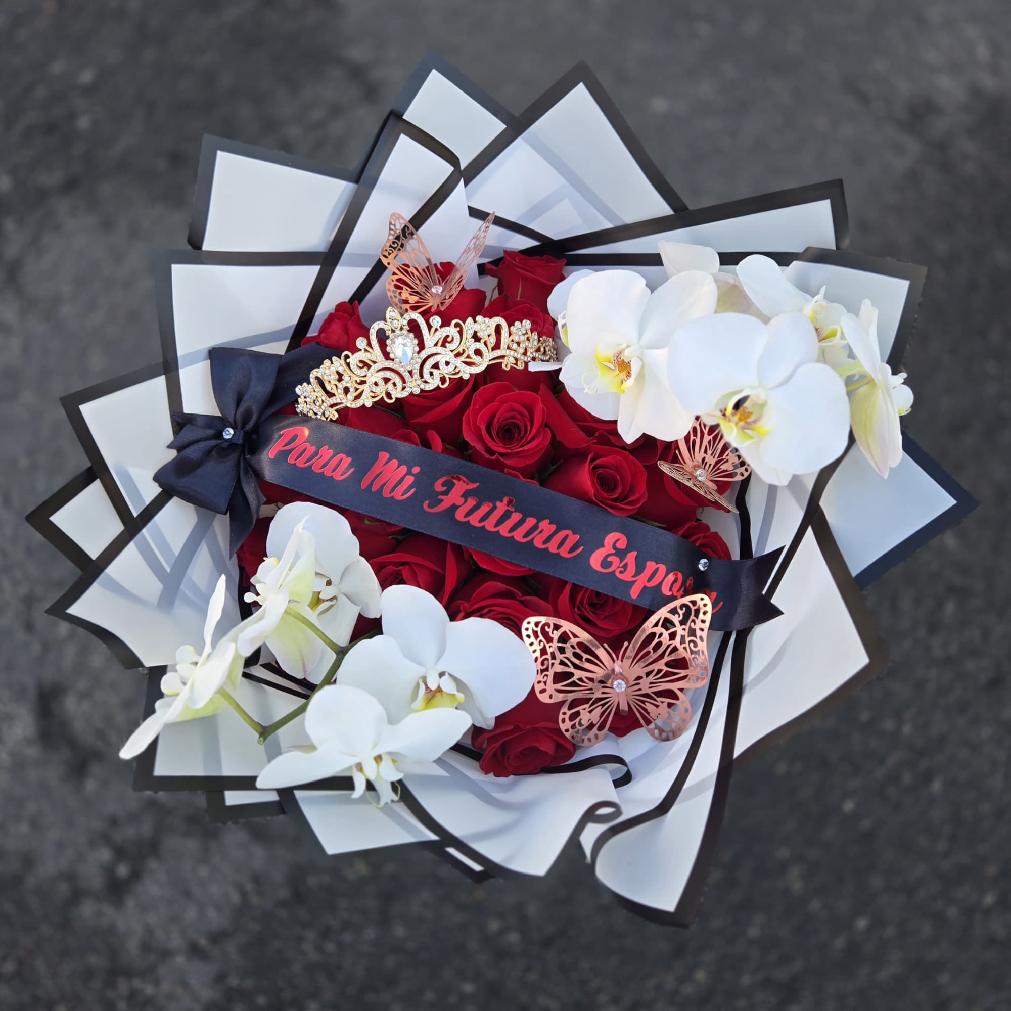 Bouquet of red roses and white orchids with decorative butterflies and ribbon