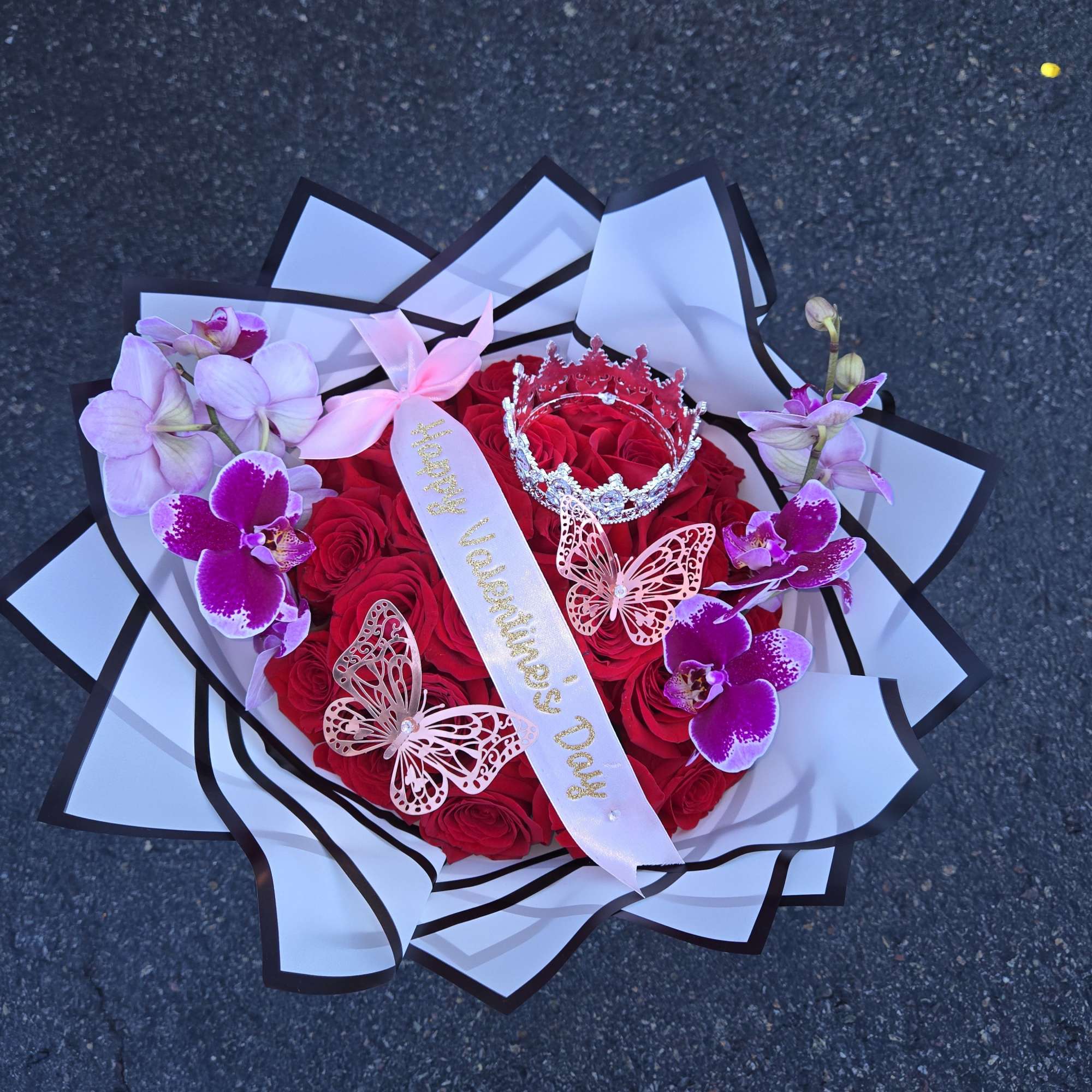 Heart-shaped bouquet of red roses with pink orchids and butterfly decorations
