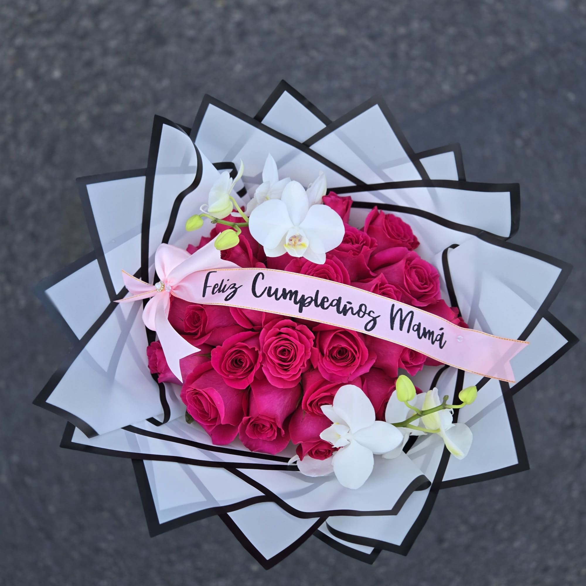 Bouquet of hot pink roses with white orchids and a birthday ribbon