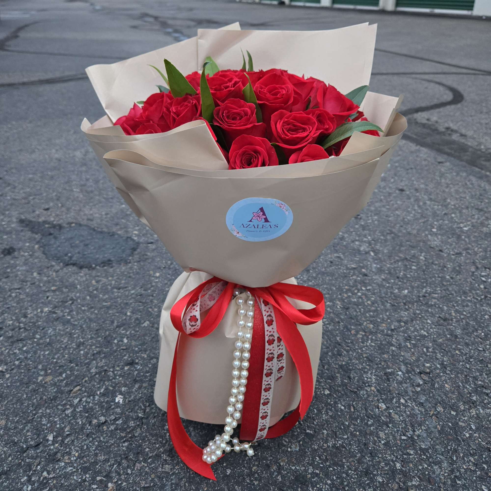 Bouquet of red roses wrapped in beige paper with a red ribbon, photo 2 of 2