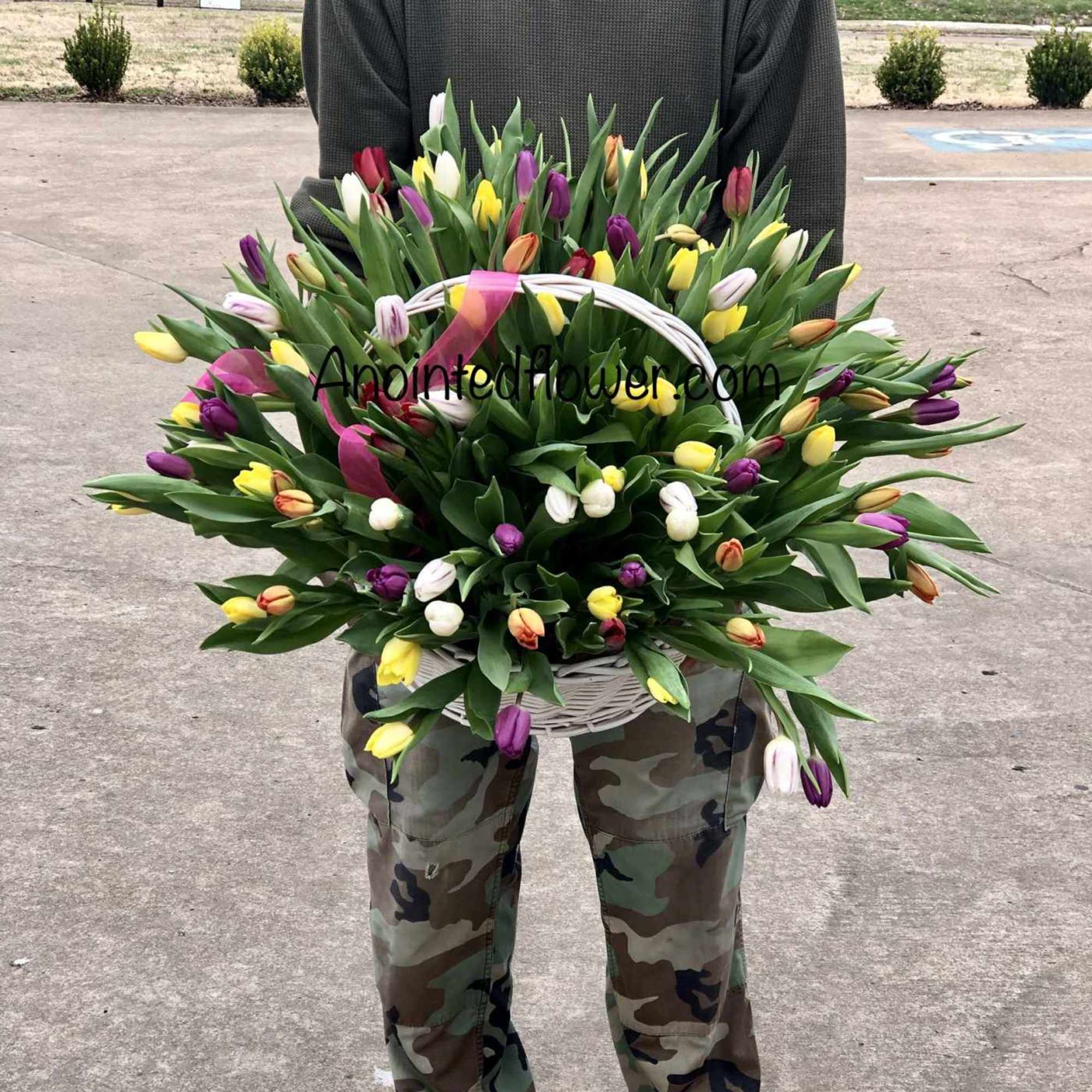 Large basket of multicolored tulips held at waist height