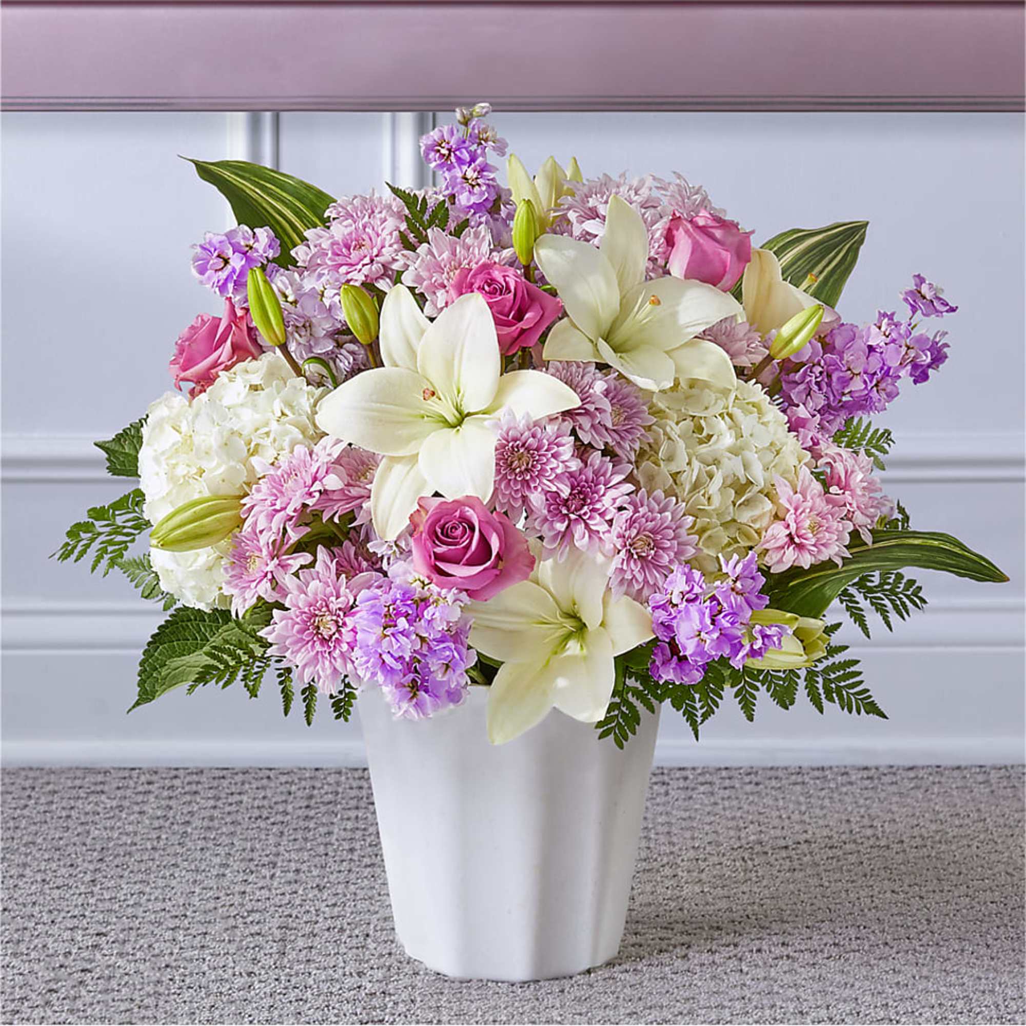 Pink and white floral arrangement in a white vase