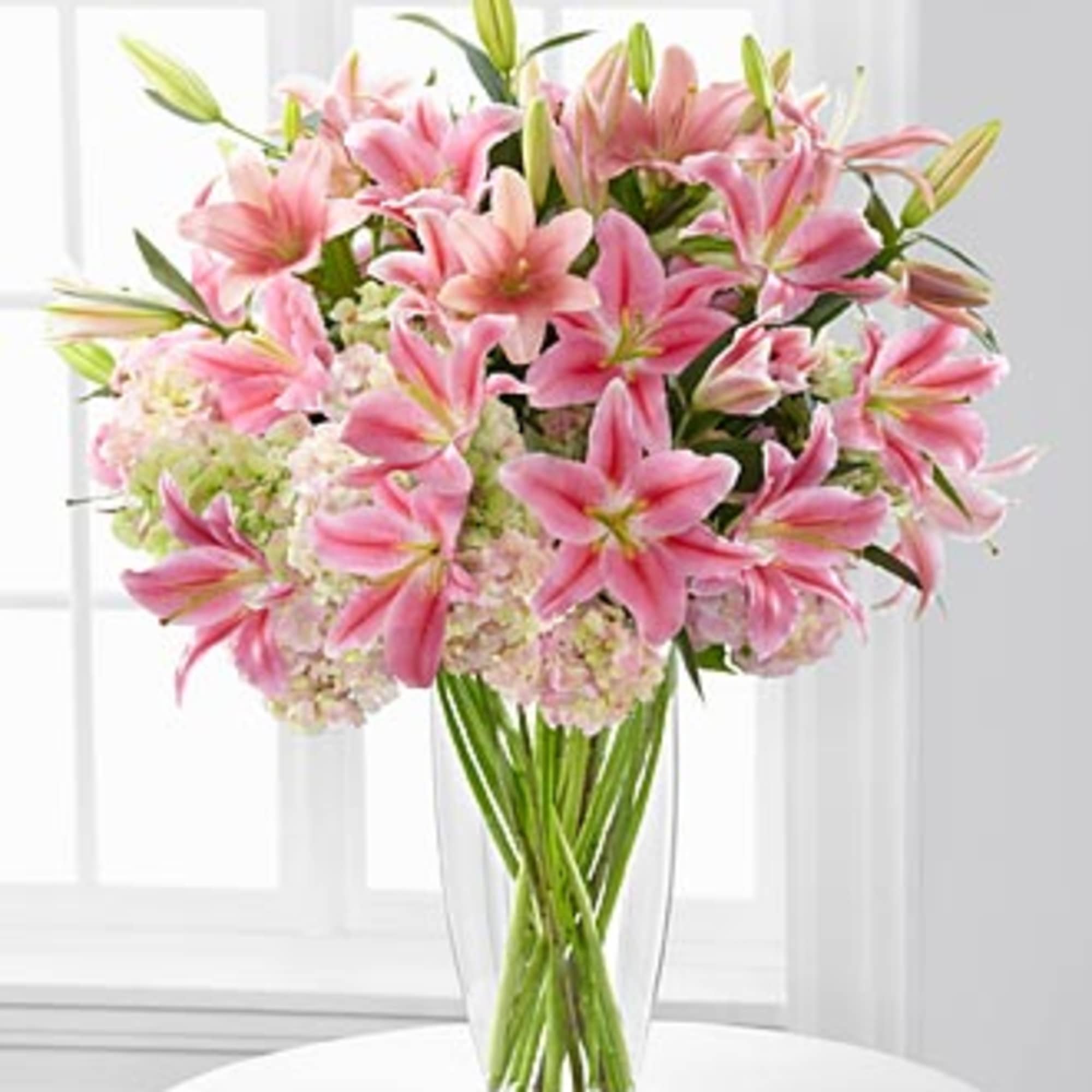 Pink lilies arranged in a clear glass vase