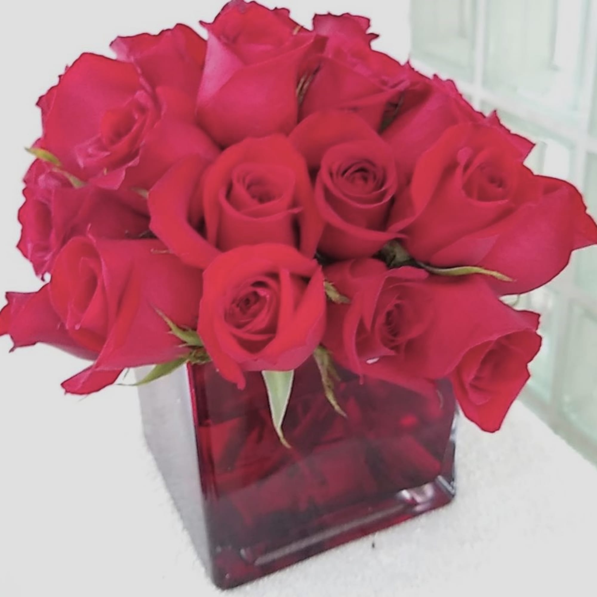 Bouquet of red roses in a square glass vase