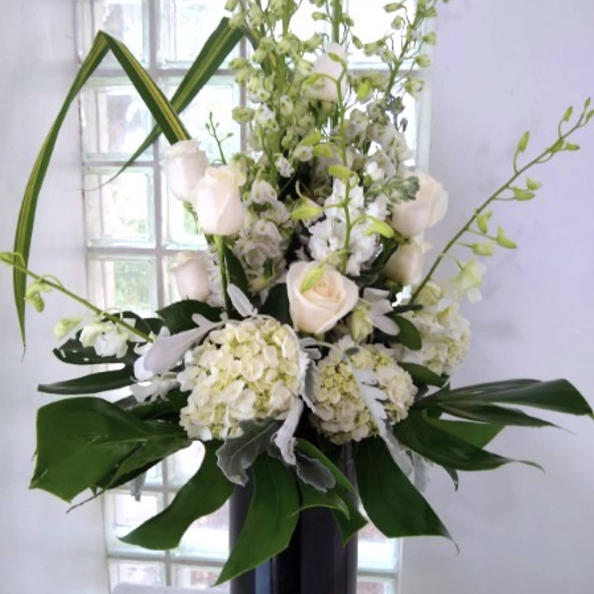 An all white arrangement in a black cylinder.   Striking! 