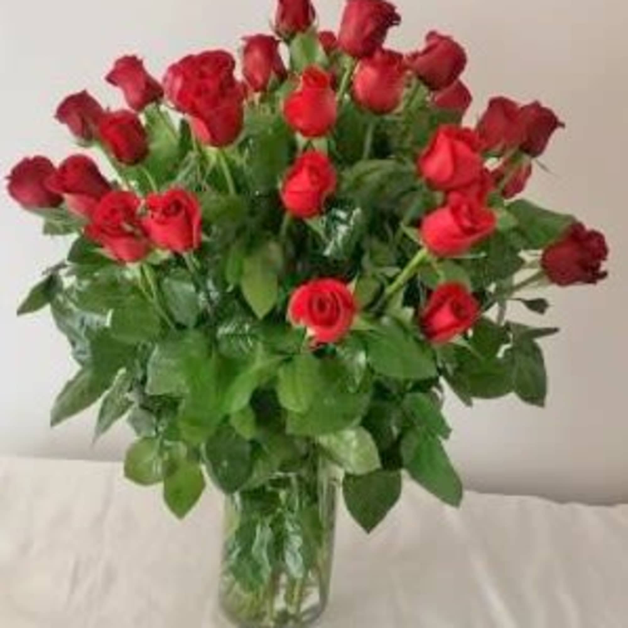 24 of our premium 70cm long stem roses arranged in a vase