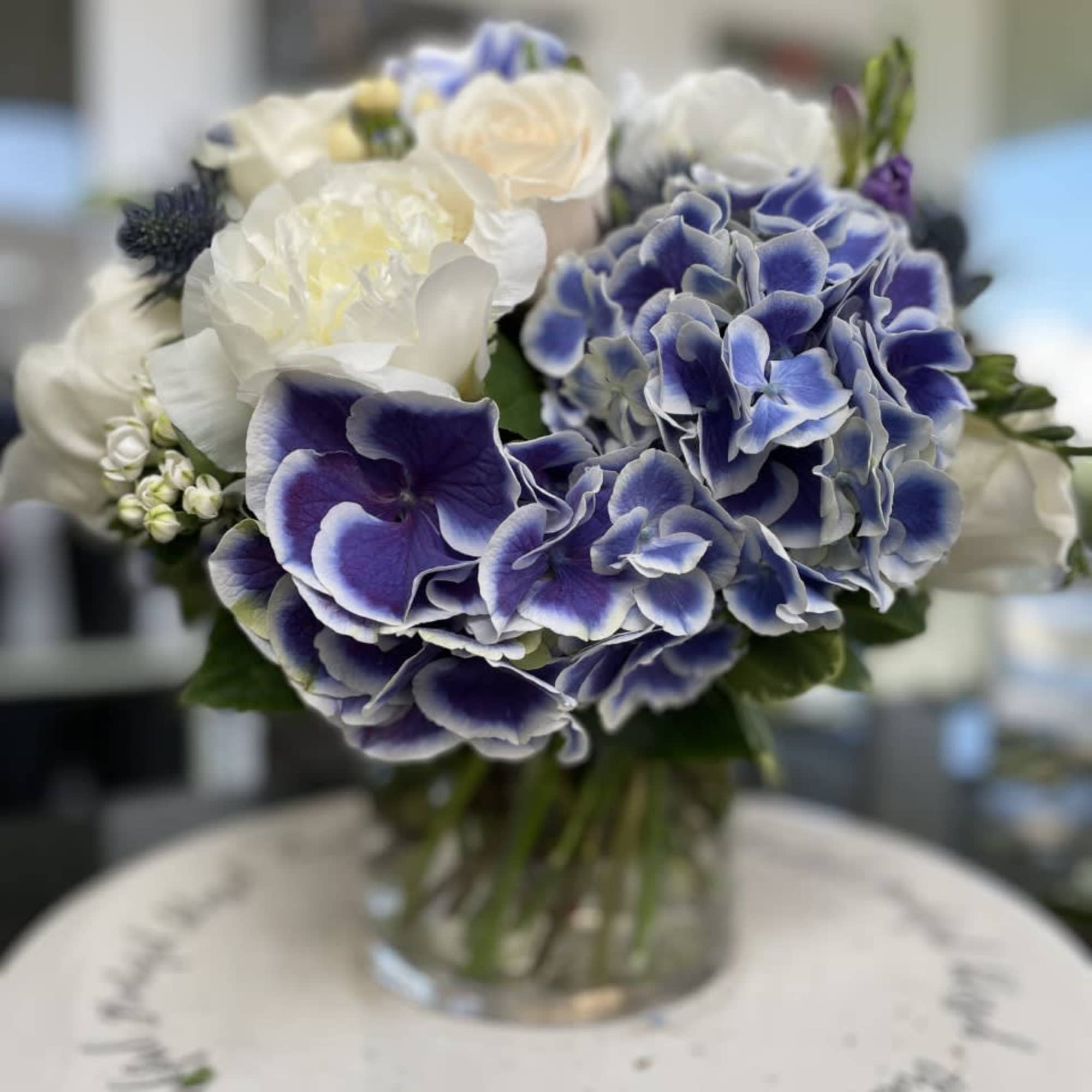 Blue and white bouquet in a clear glass vase
