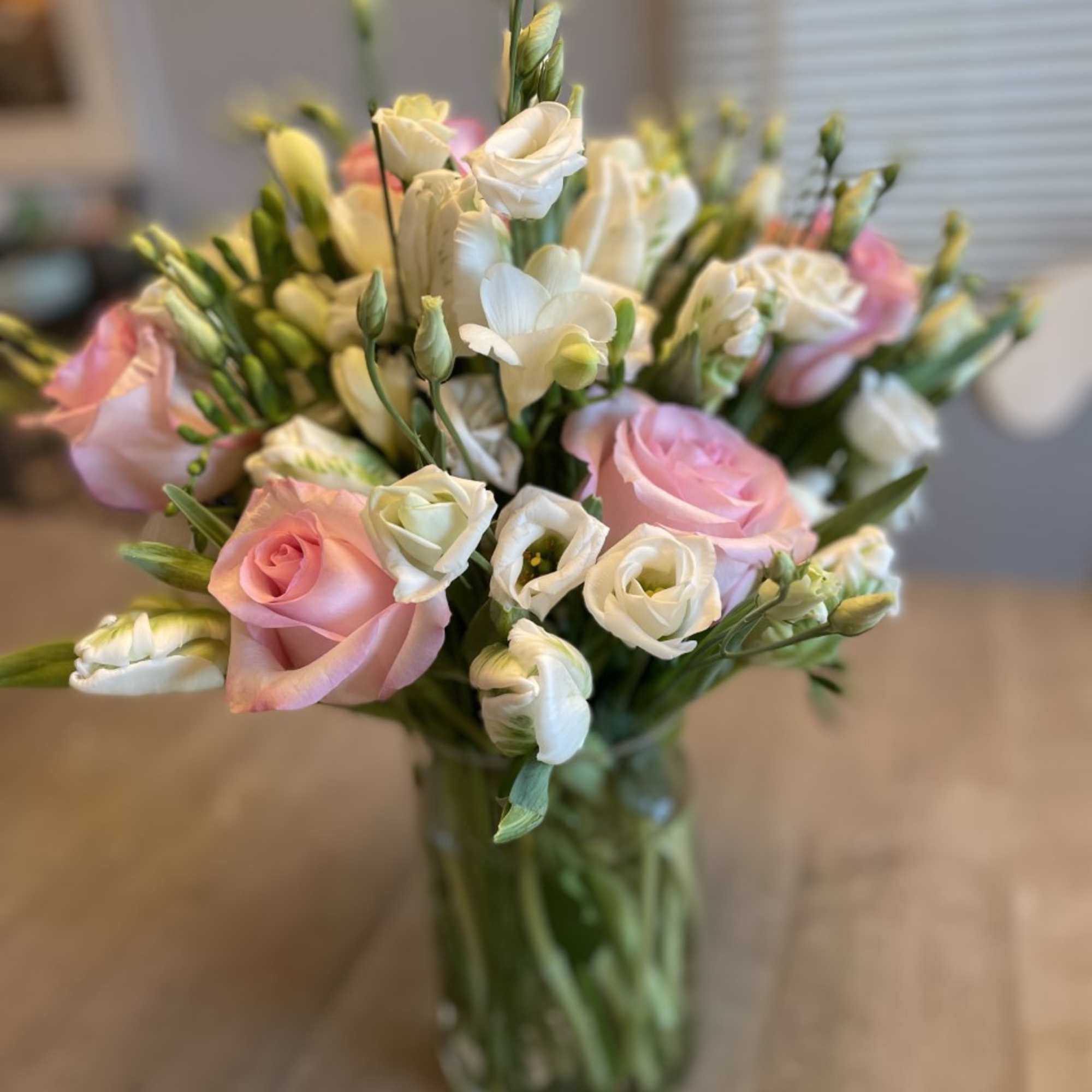Pink roses and white lisianthus in a glass vase