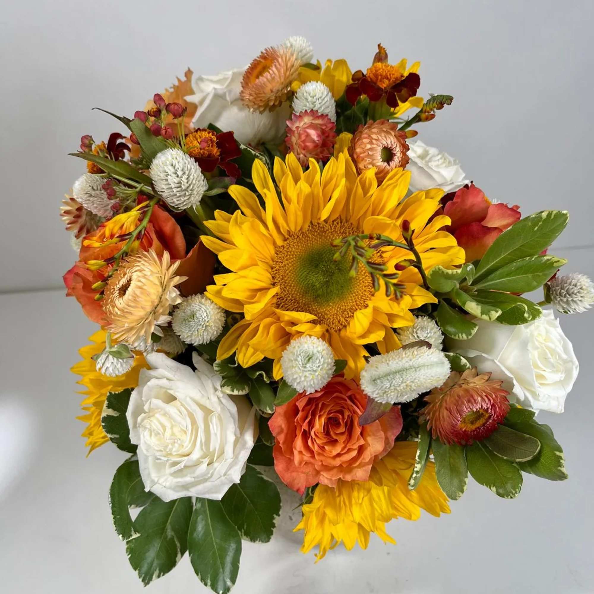 Bouquet with sunflowers, white roses, and orange blooms