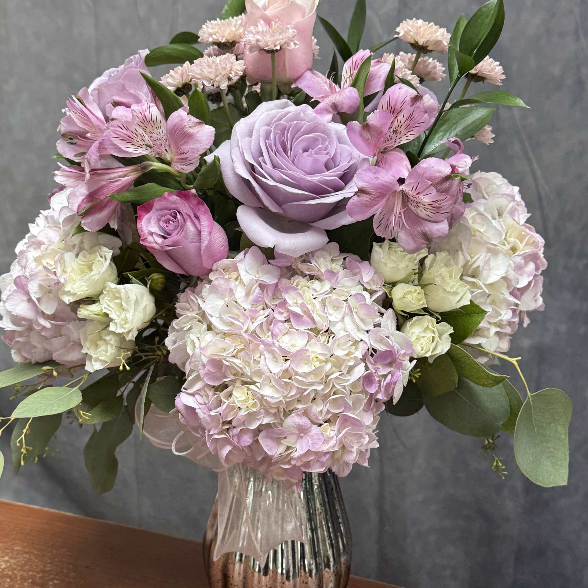 Pink and lavender flower arrangement in a glass vase