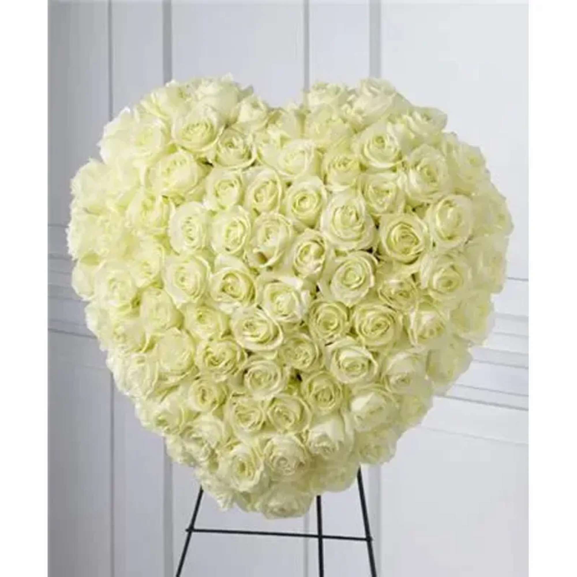 77 stems of white roses are artfully arranged in the shape of