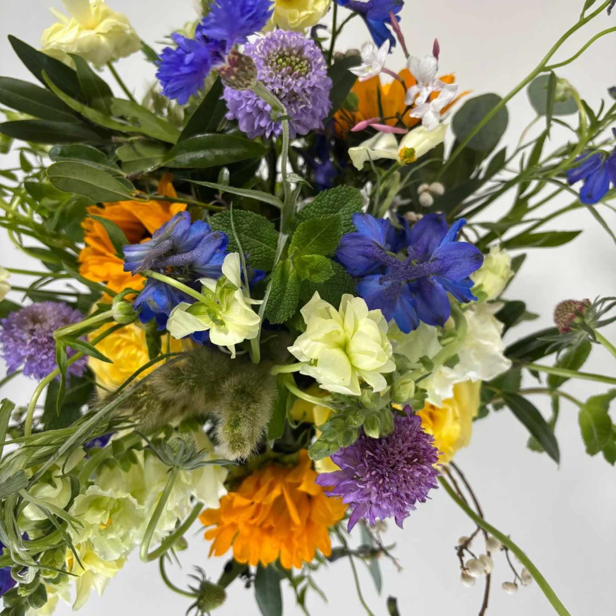 Mixed bouquet with blue, yellow, orange, and purple flowers, photo 4 of 6