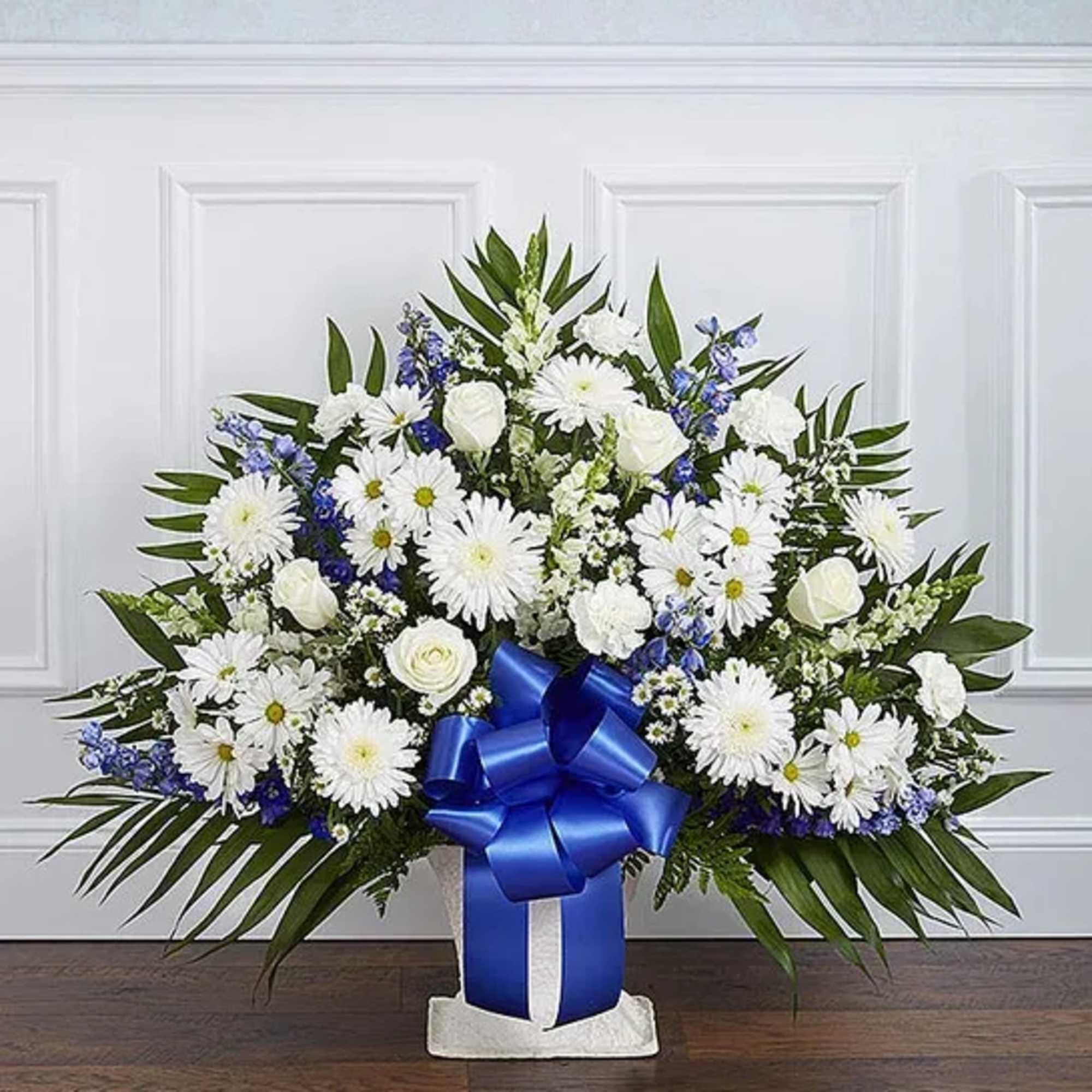 White daisies and roses in a blue ribboned vase arrangement