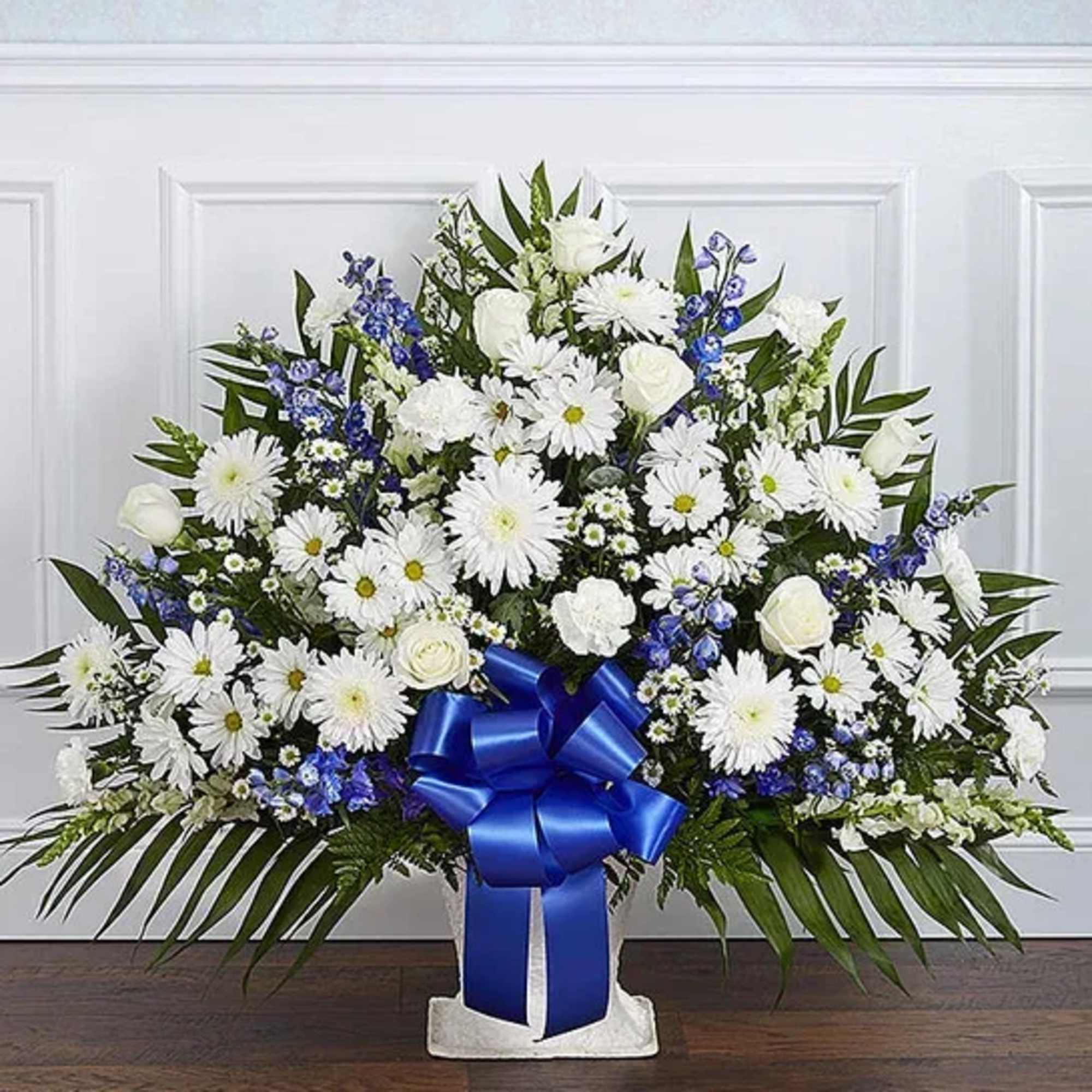 White floral standing spray with a blue ribbon bow