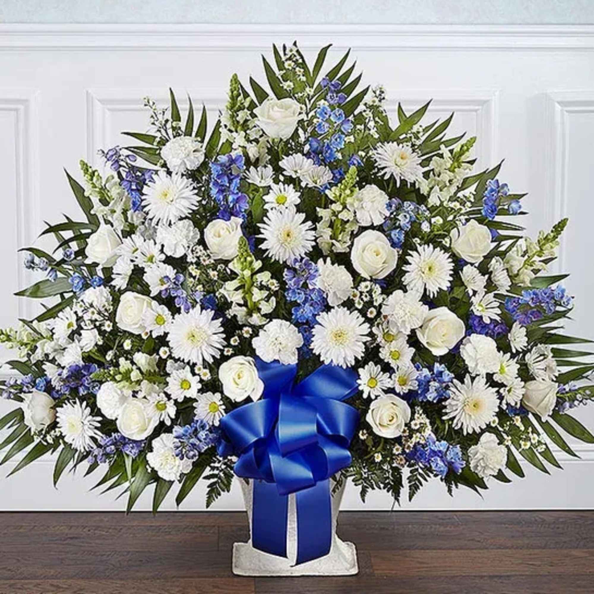 Large white and blue floral standing spray with a blue ribbon