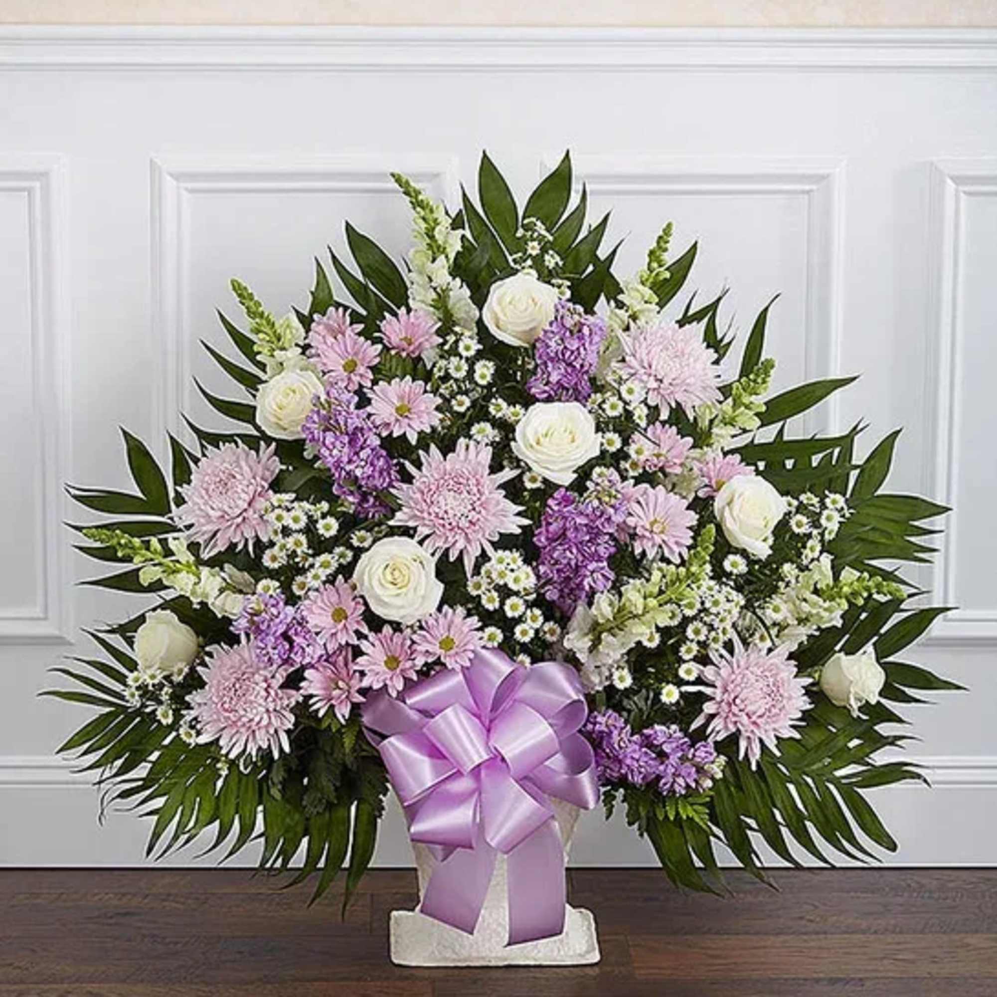 Standing floral spray with pink and white flowers and a lavender ribbon
