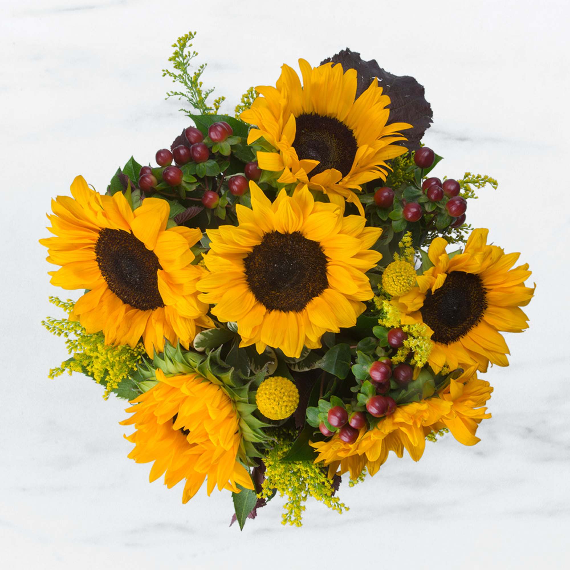 Bouquet of yellow sunflowers with red berry accents