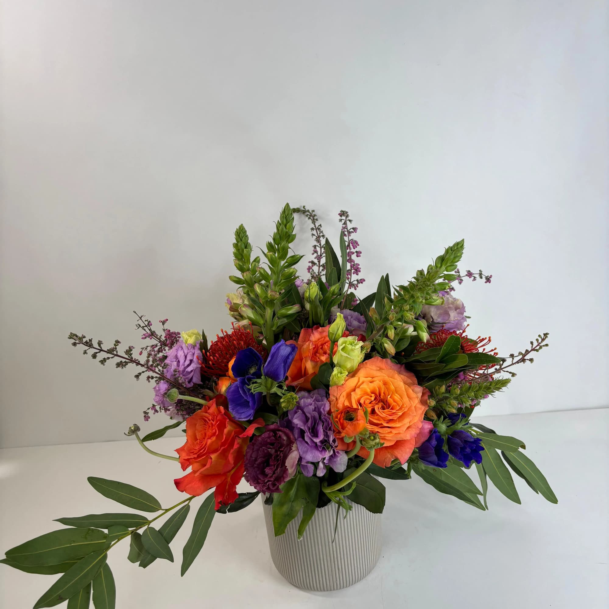 Colorful mixed flower arrangement in a striped vase