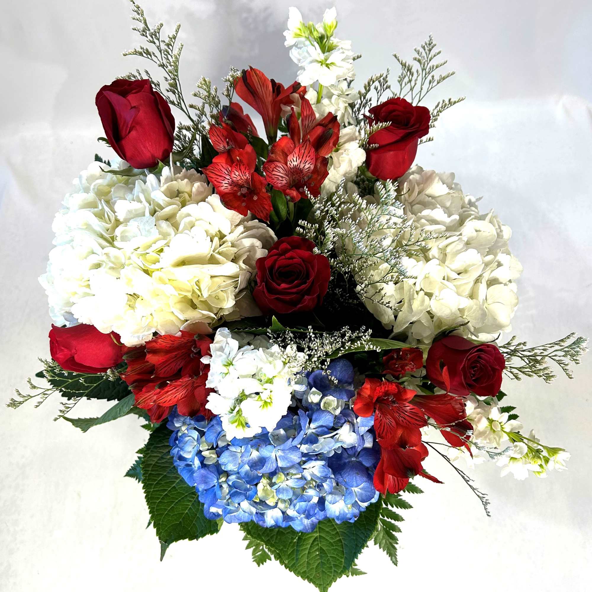Bouquet of red roses, white hydrangeas, and blue hydrangeas