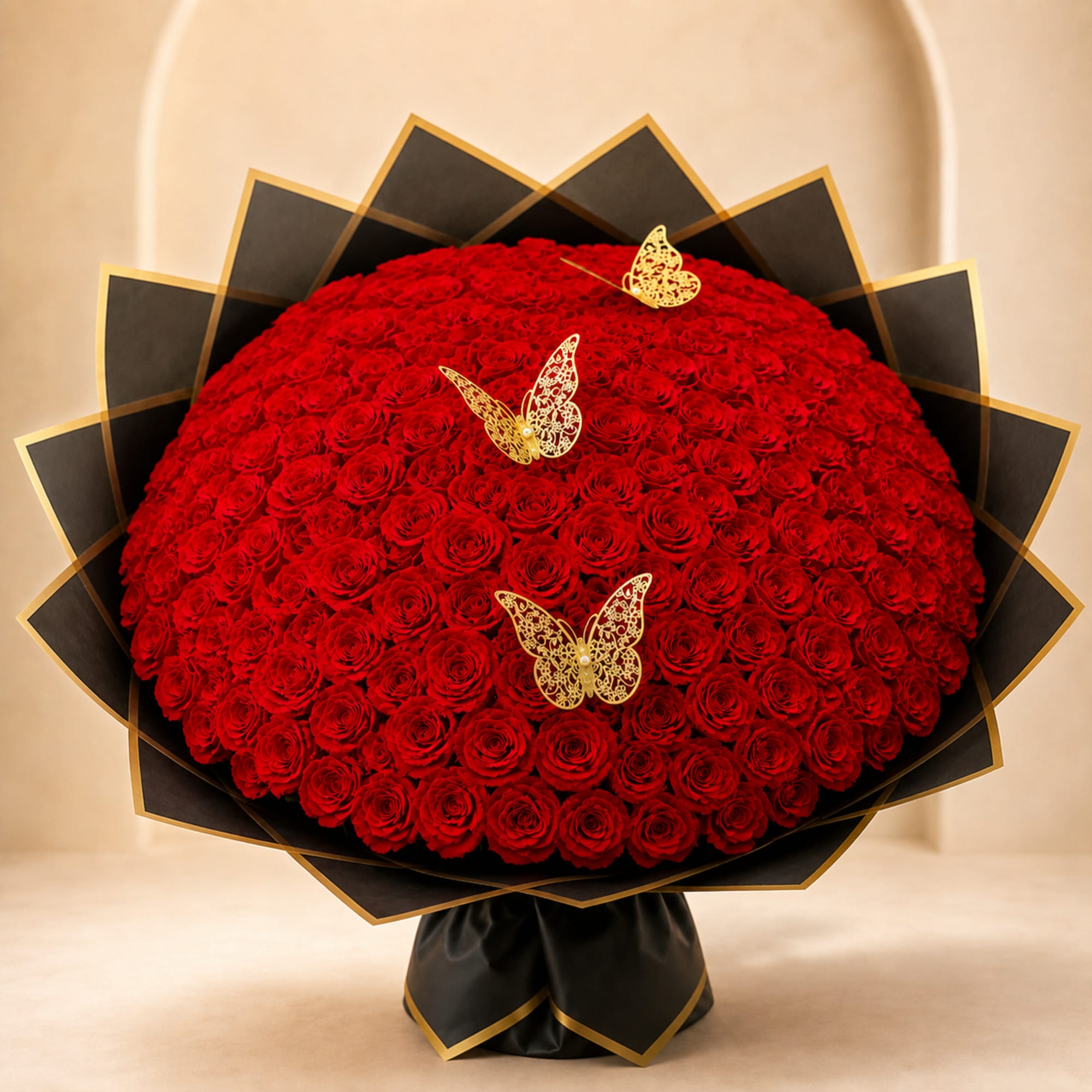 Large bouquet of red roses with black and gold wrapping and butterfly accents