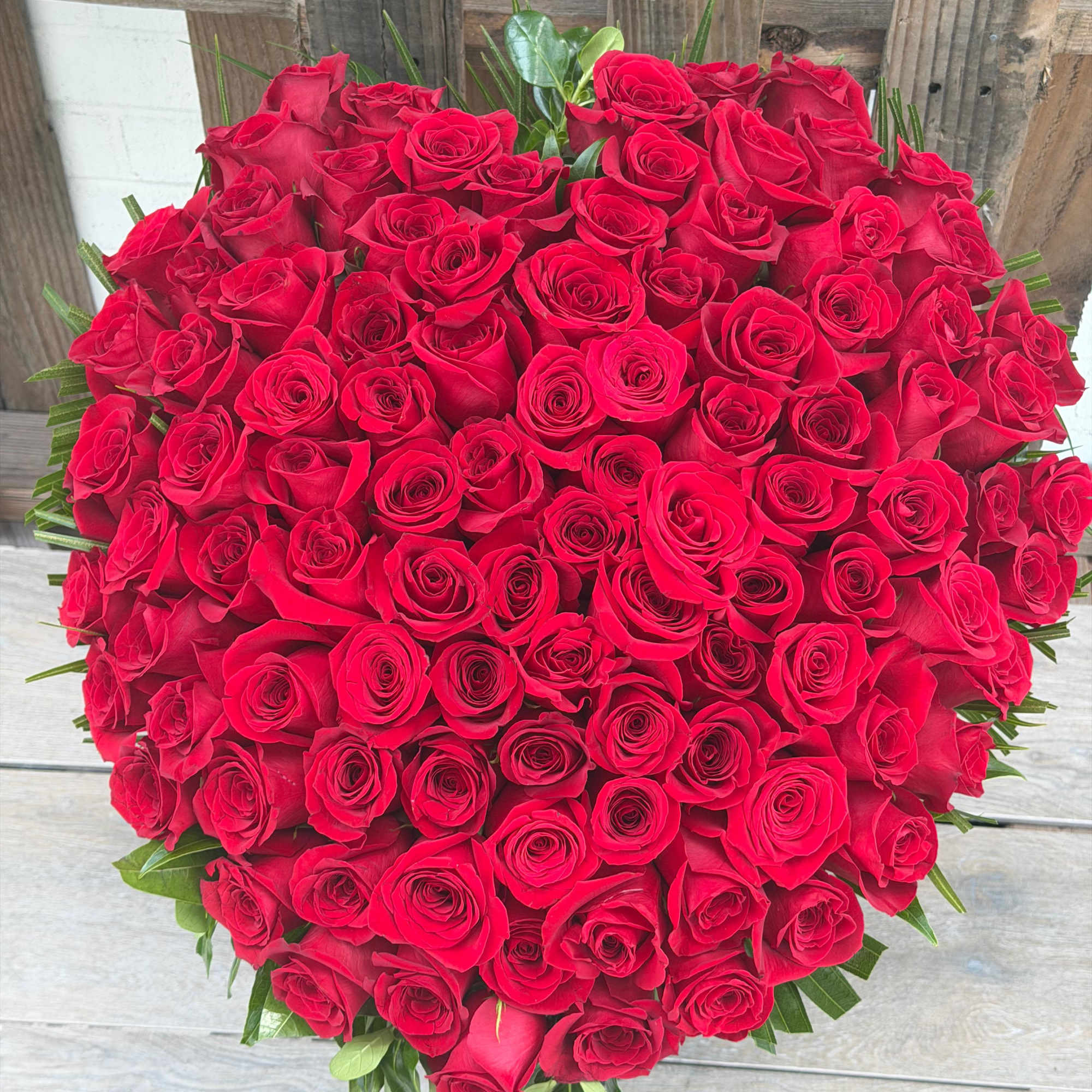 Large bouquet of red roses with green foliage