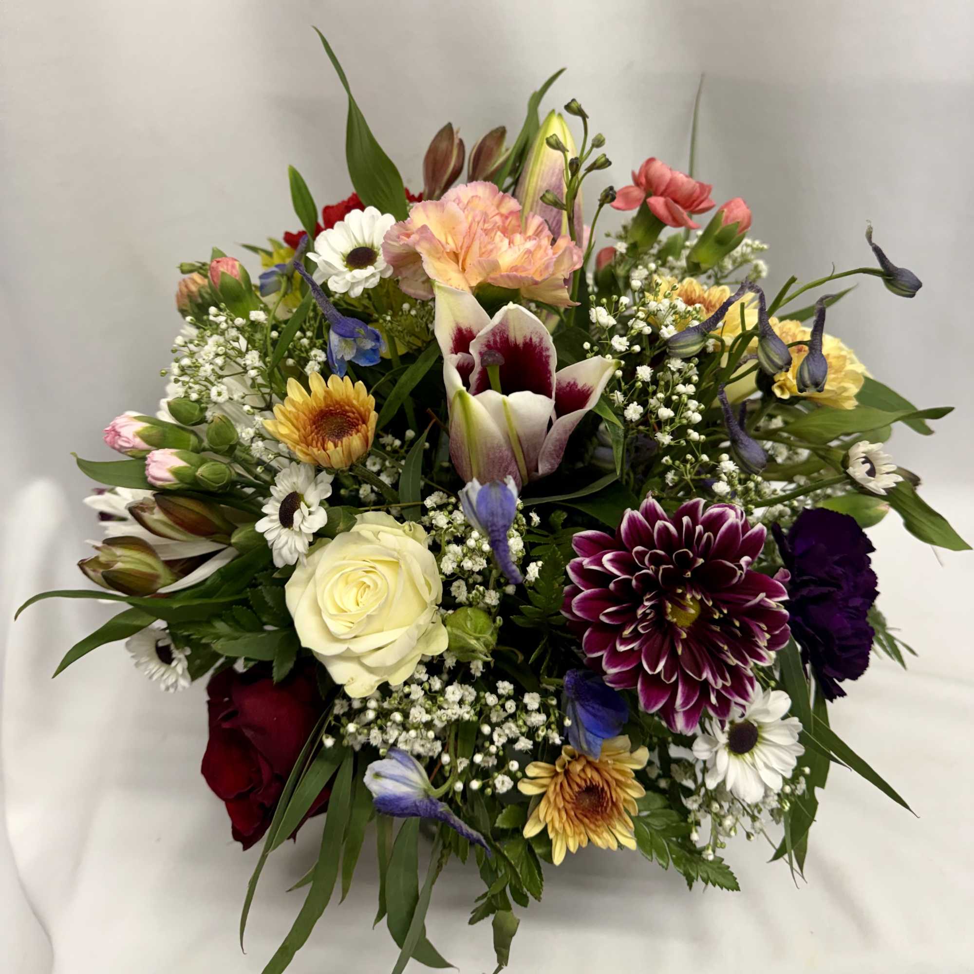 Mixed bouquet with roses, lilies, daisies, and colorful blooms