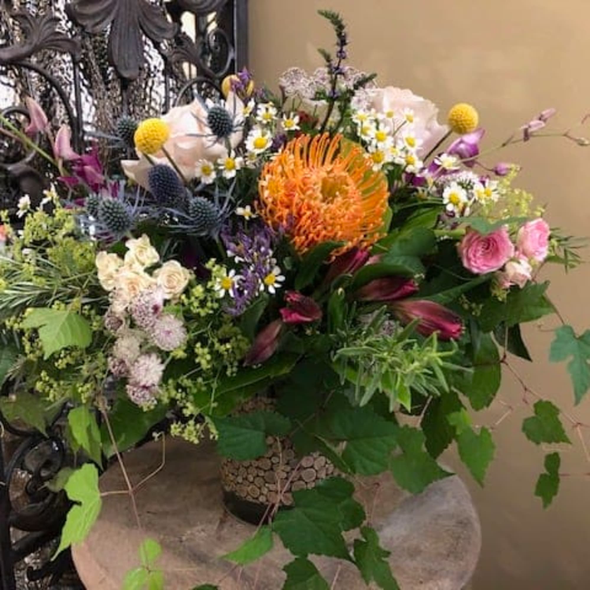 Mixed bouquet with orange, pink, white, and purple flowers in a decorative vase