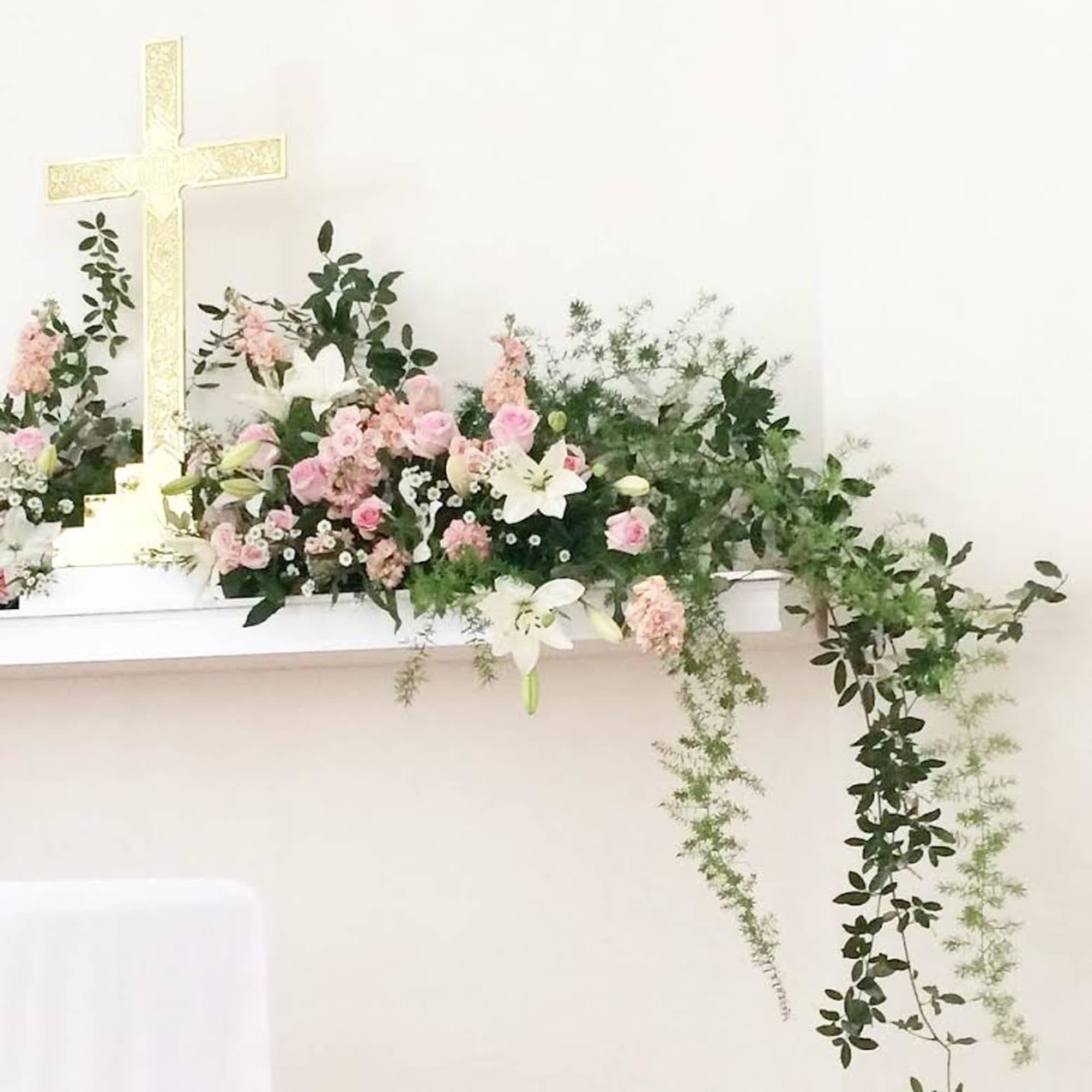 Pastel floral arrangement with a large cross centerpiece