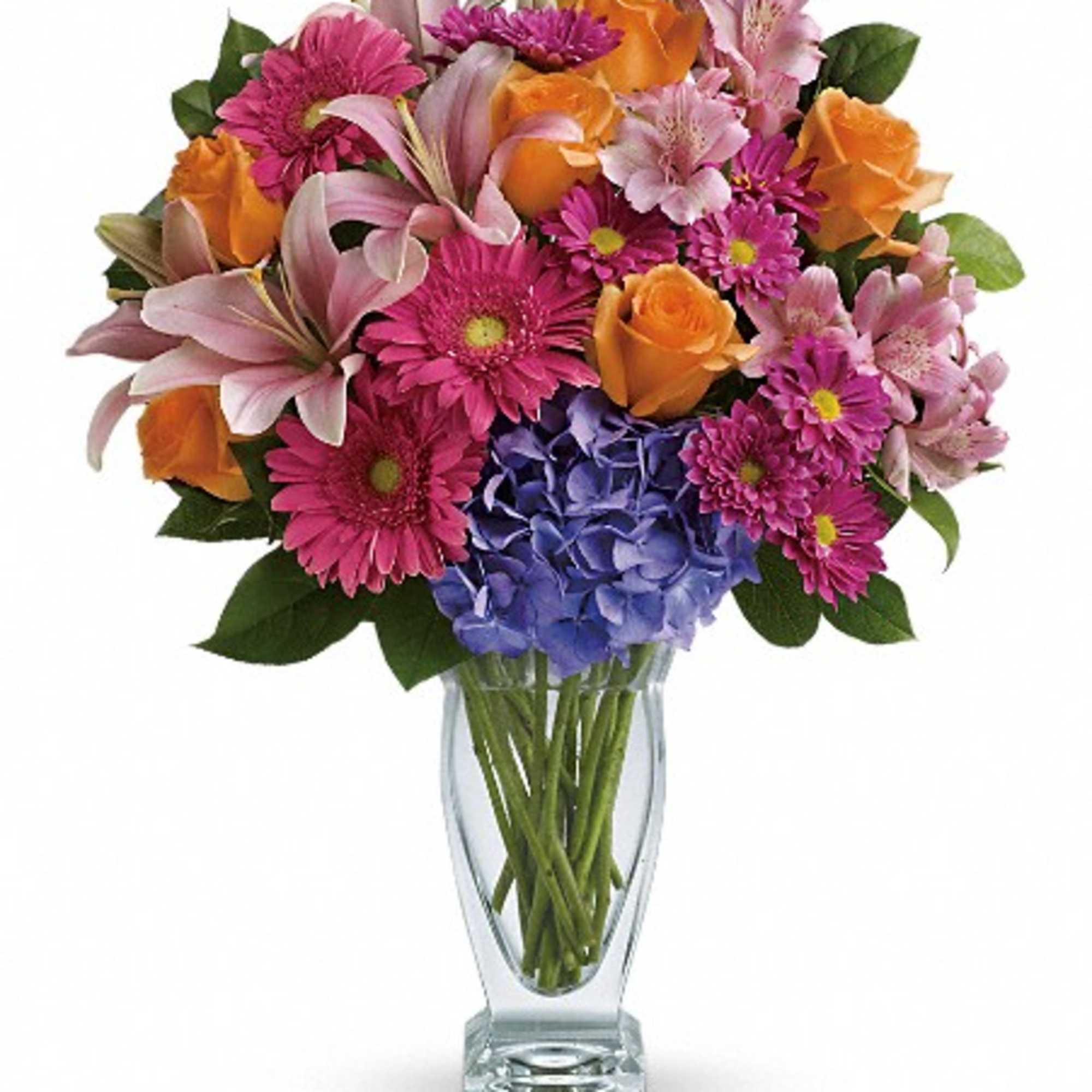Mixed bouquet of pink, orange, and purple flowers in a clear glass vase, photo 3 of 3