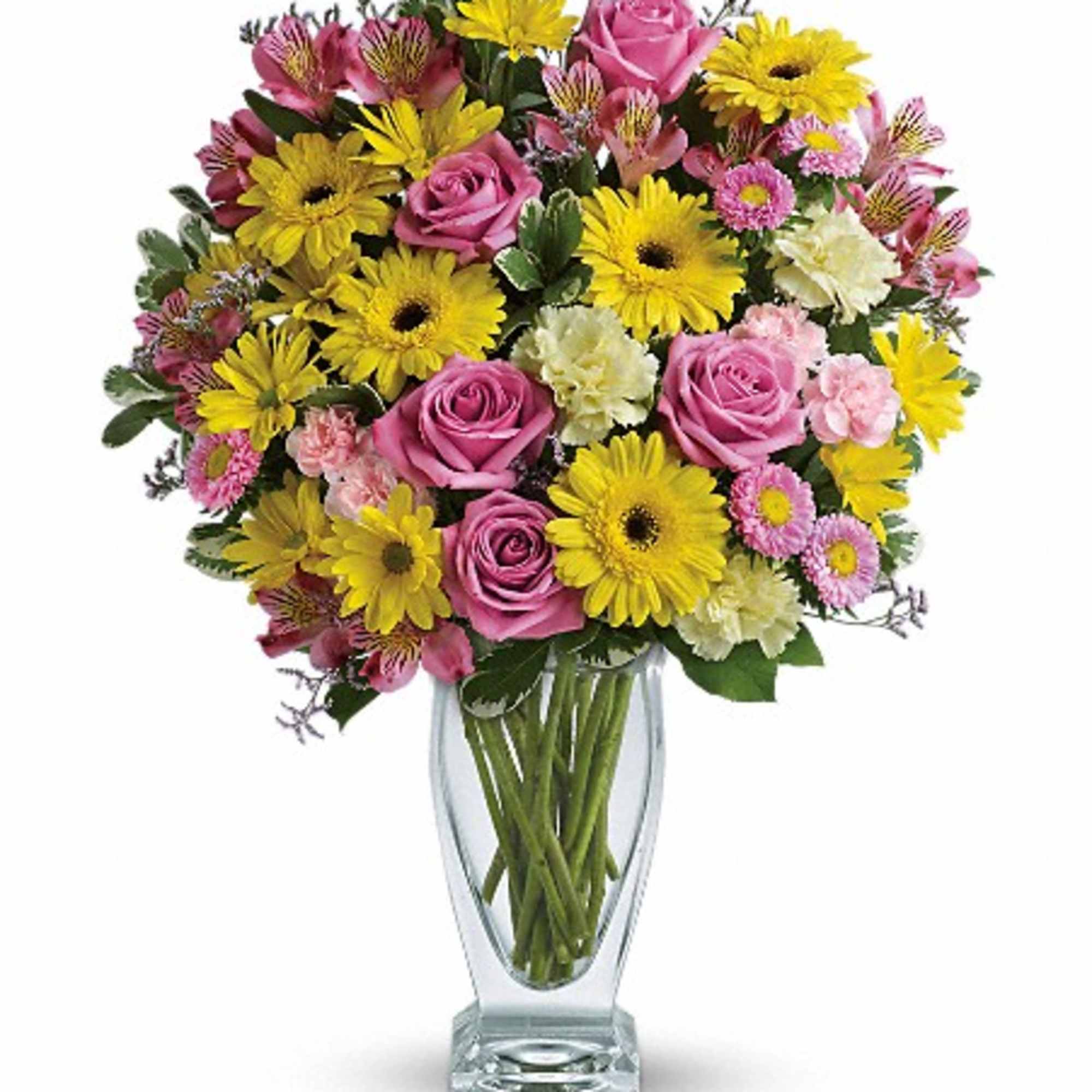 Pink roses and yellow daisies arranged in a clear glass vase