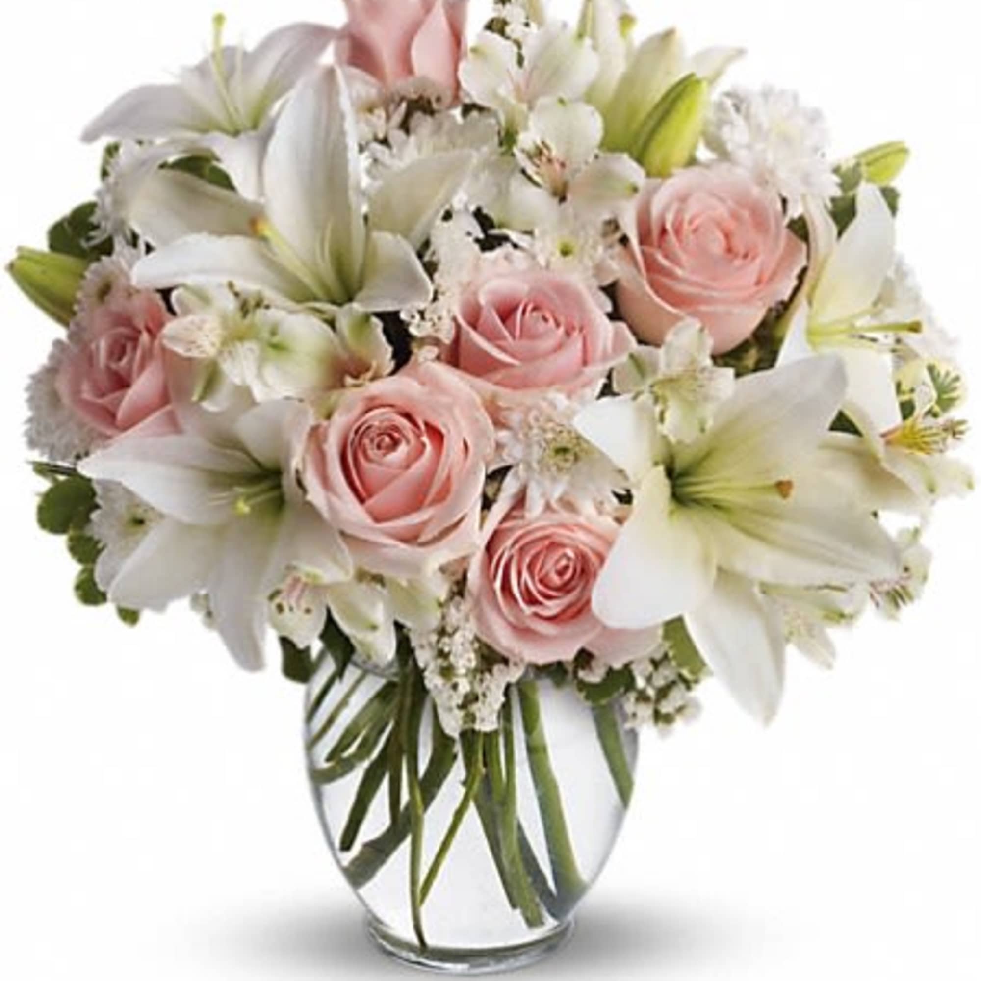 Pink roses and white lilies arranged in a clear glass vase
