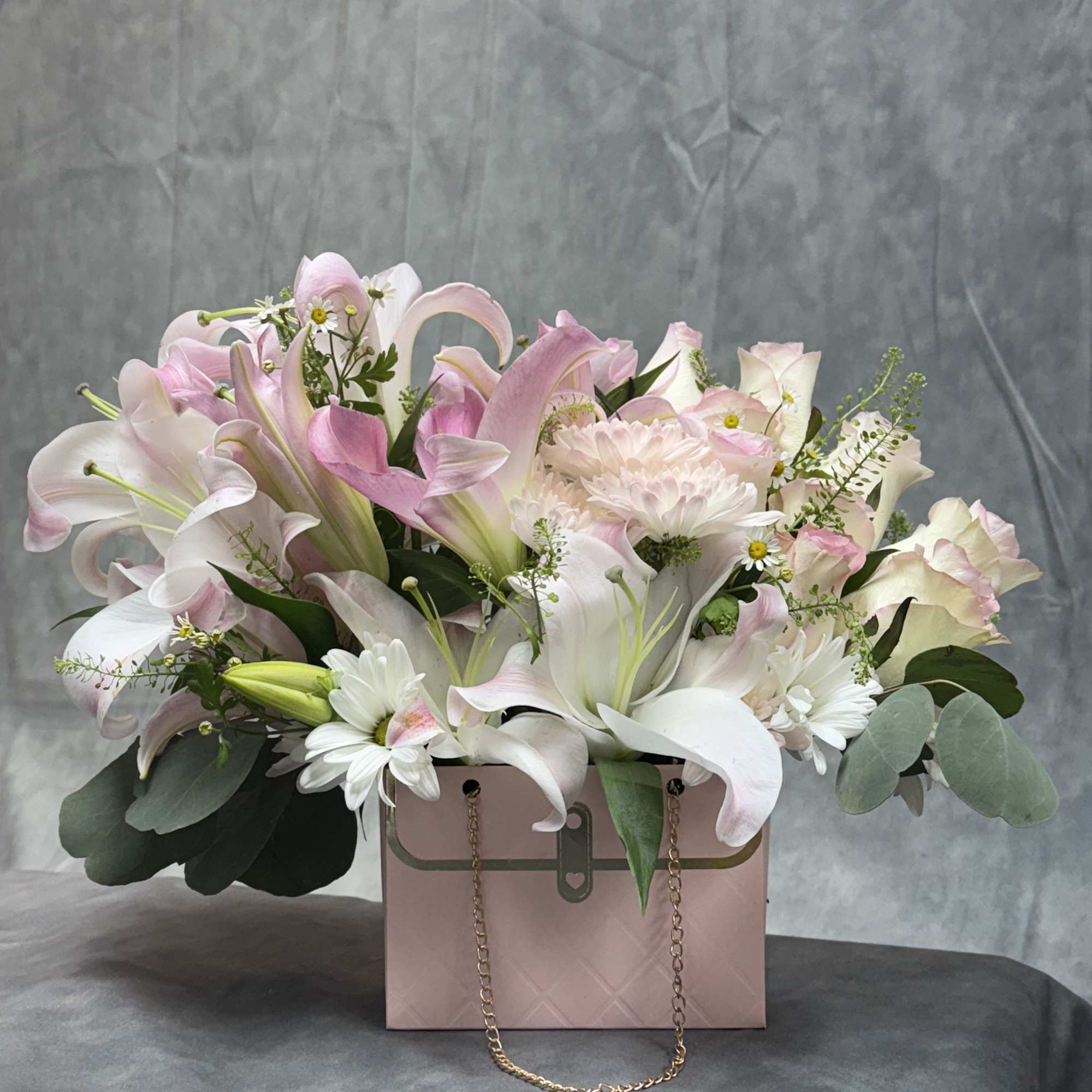 Pink and white lilies with daisies in a pink gift box